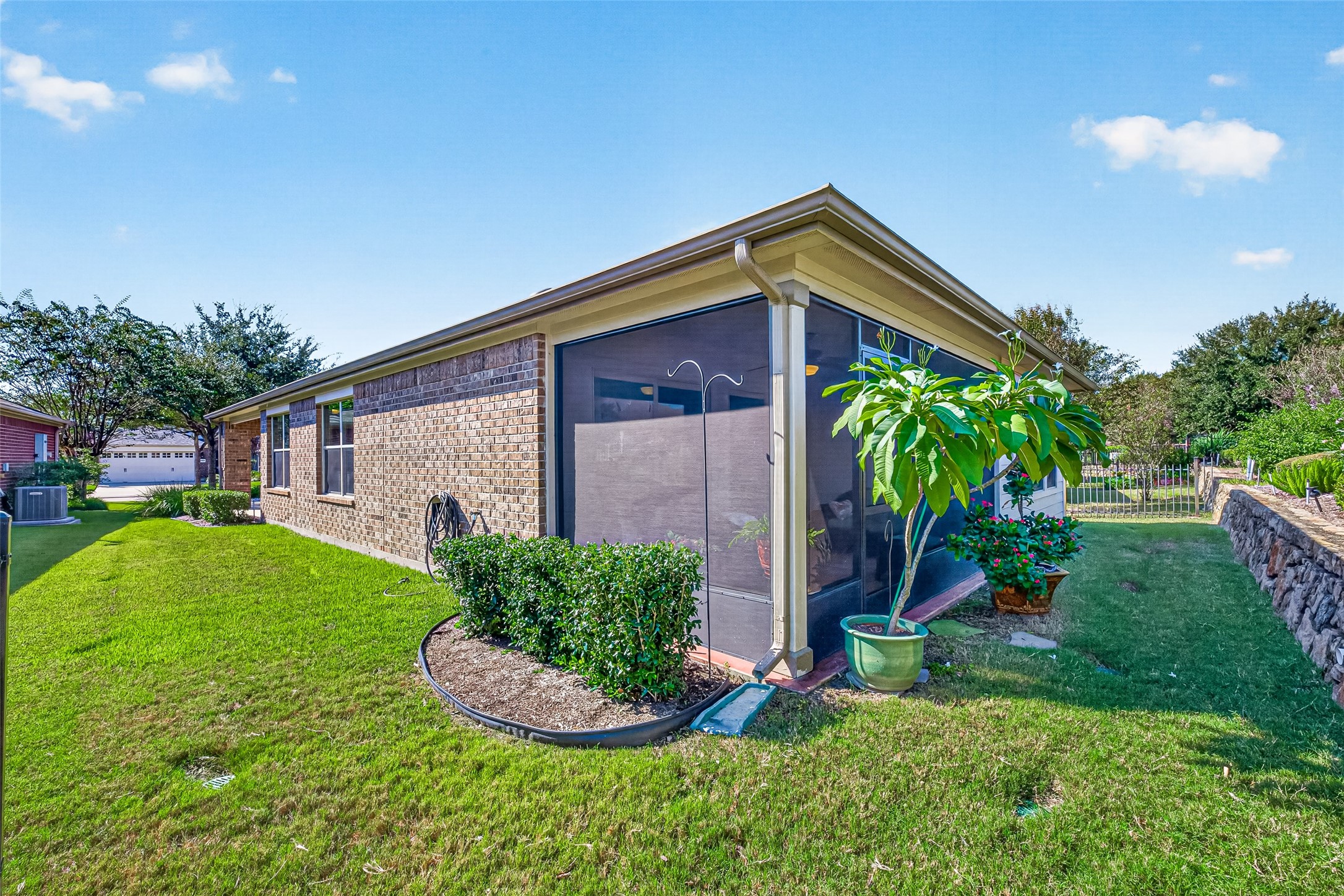 Charming rear exterior surrounded by well-kept landscaping.