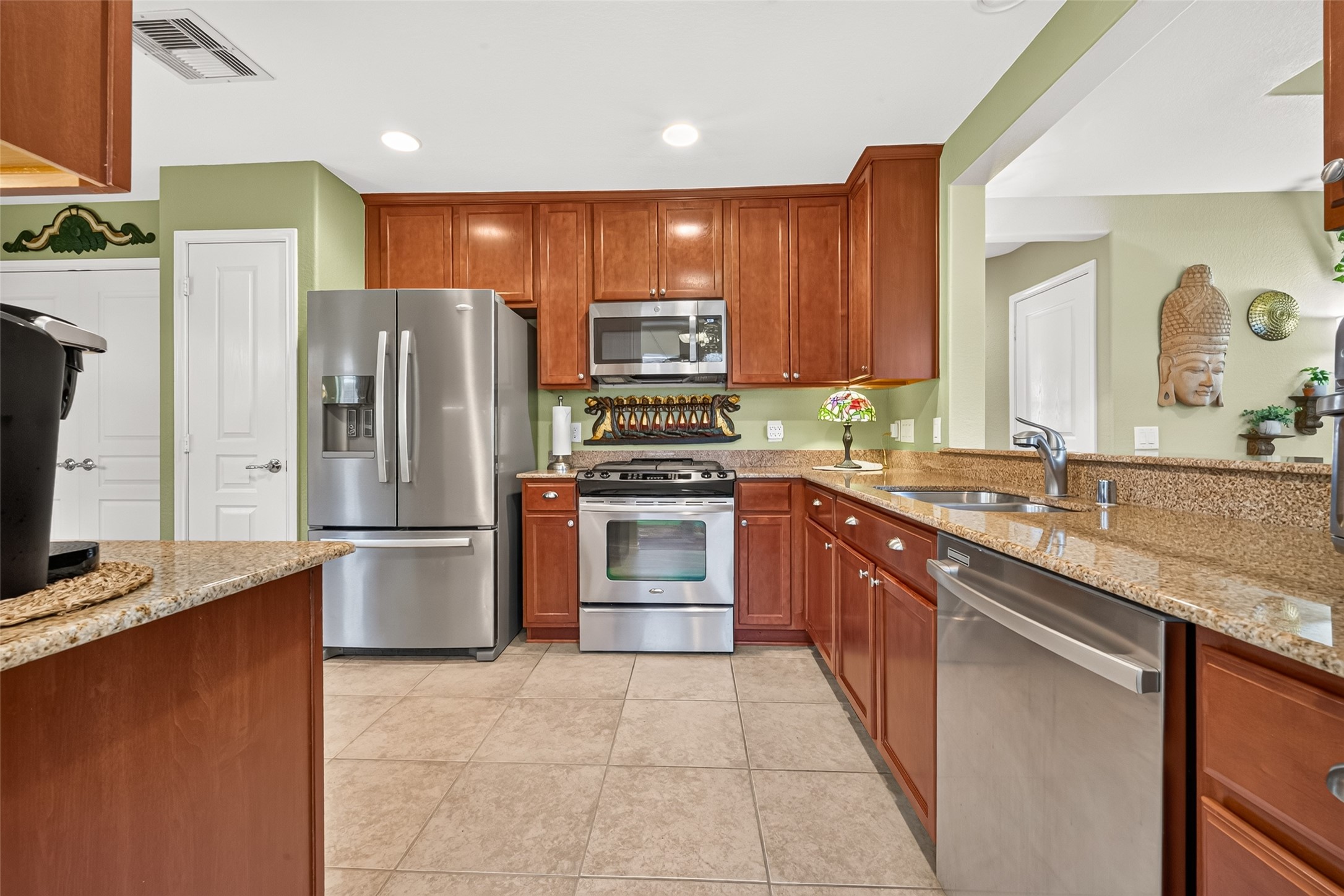 Warm cabinetry, granite counters, and stainless appliances create an inviting kitchen.