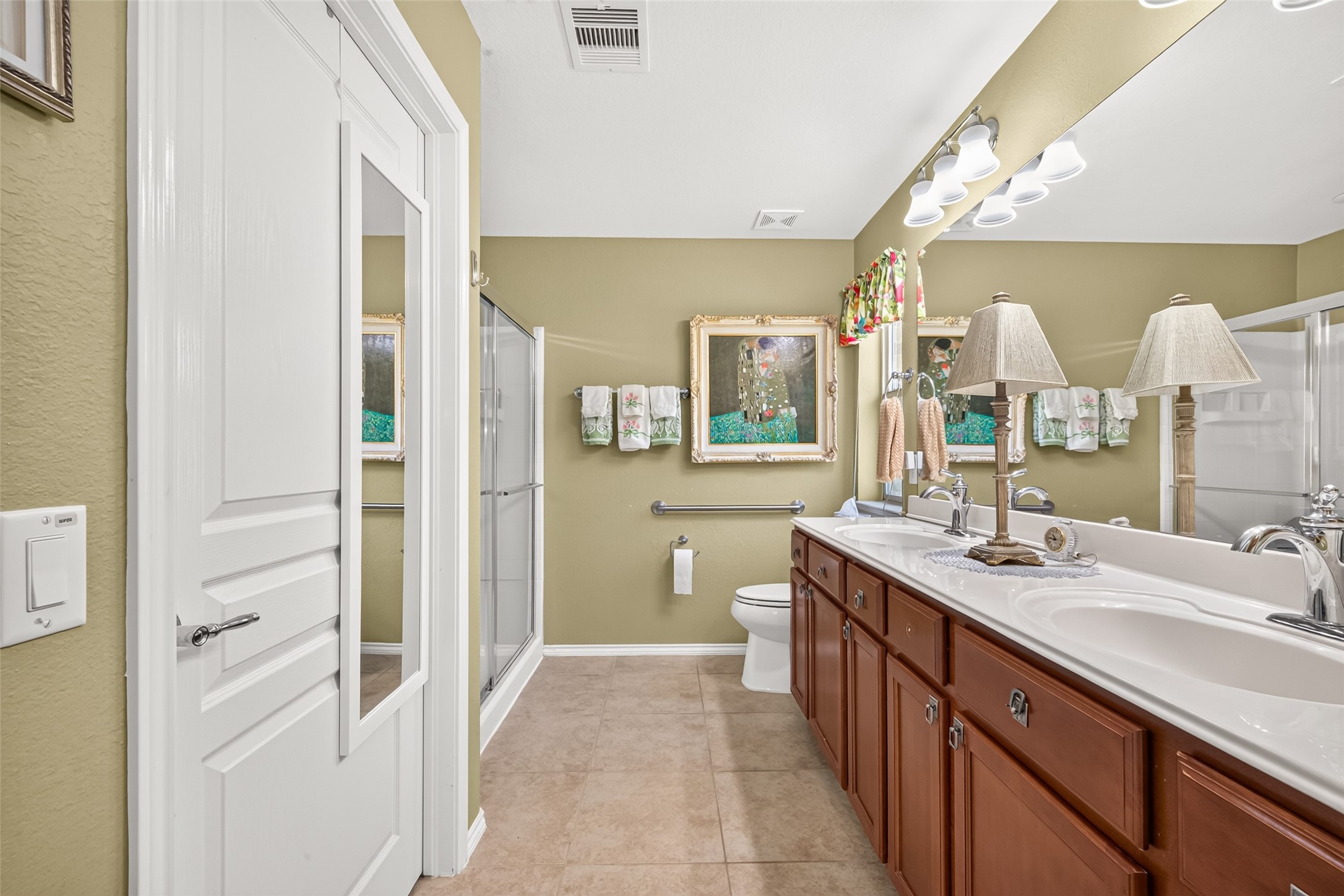 A spacious primary bathroom with a large shower and generous vanity.