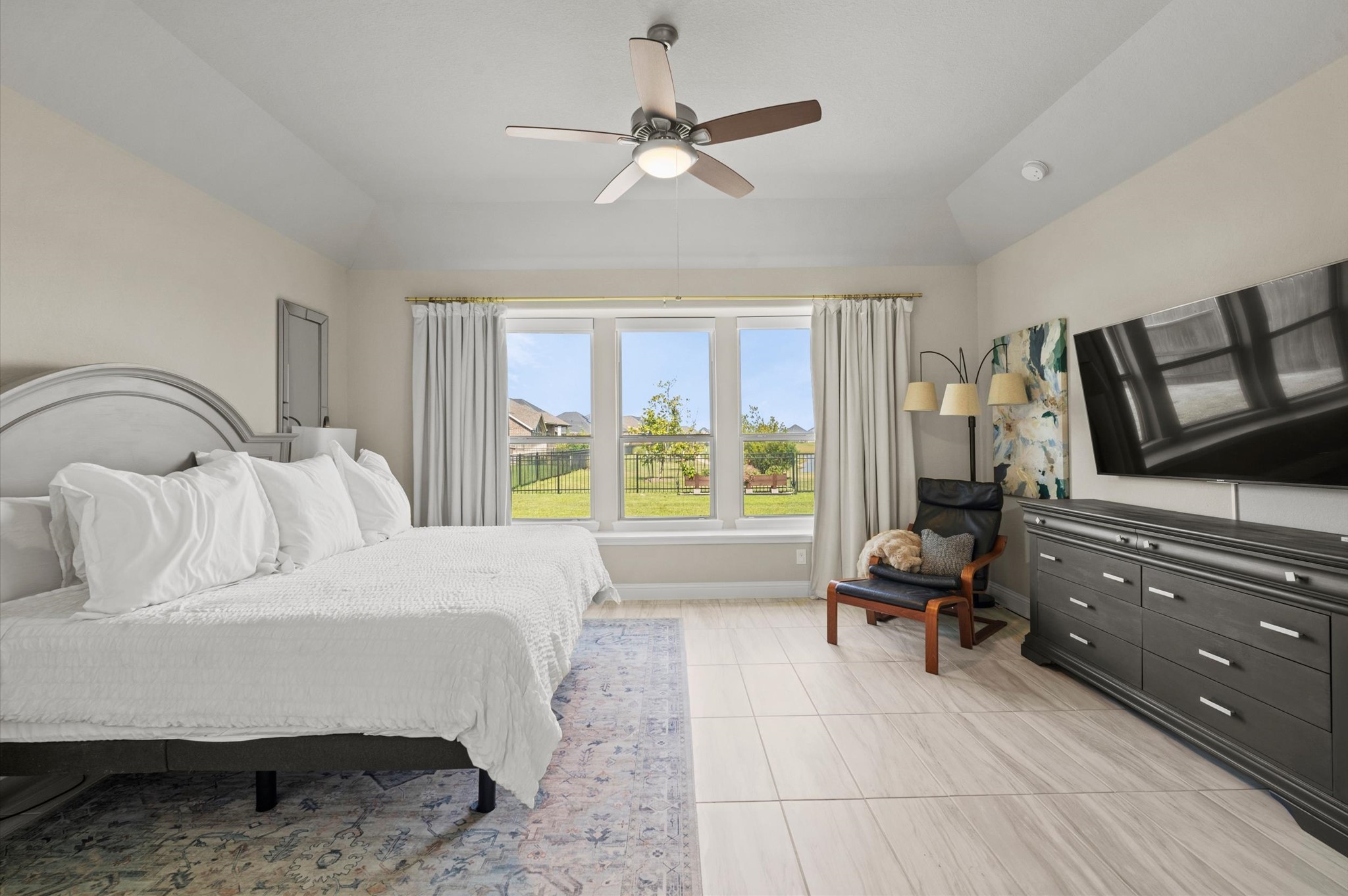 Spacious primacy bedroom with large windows overlooking the lake, and smart shades for privacy.