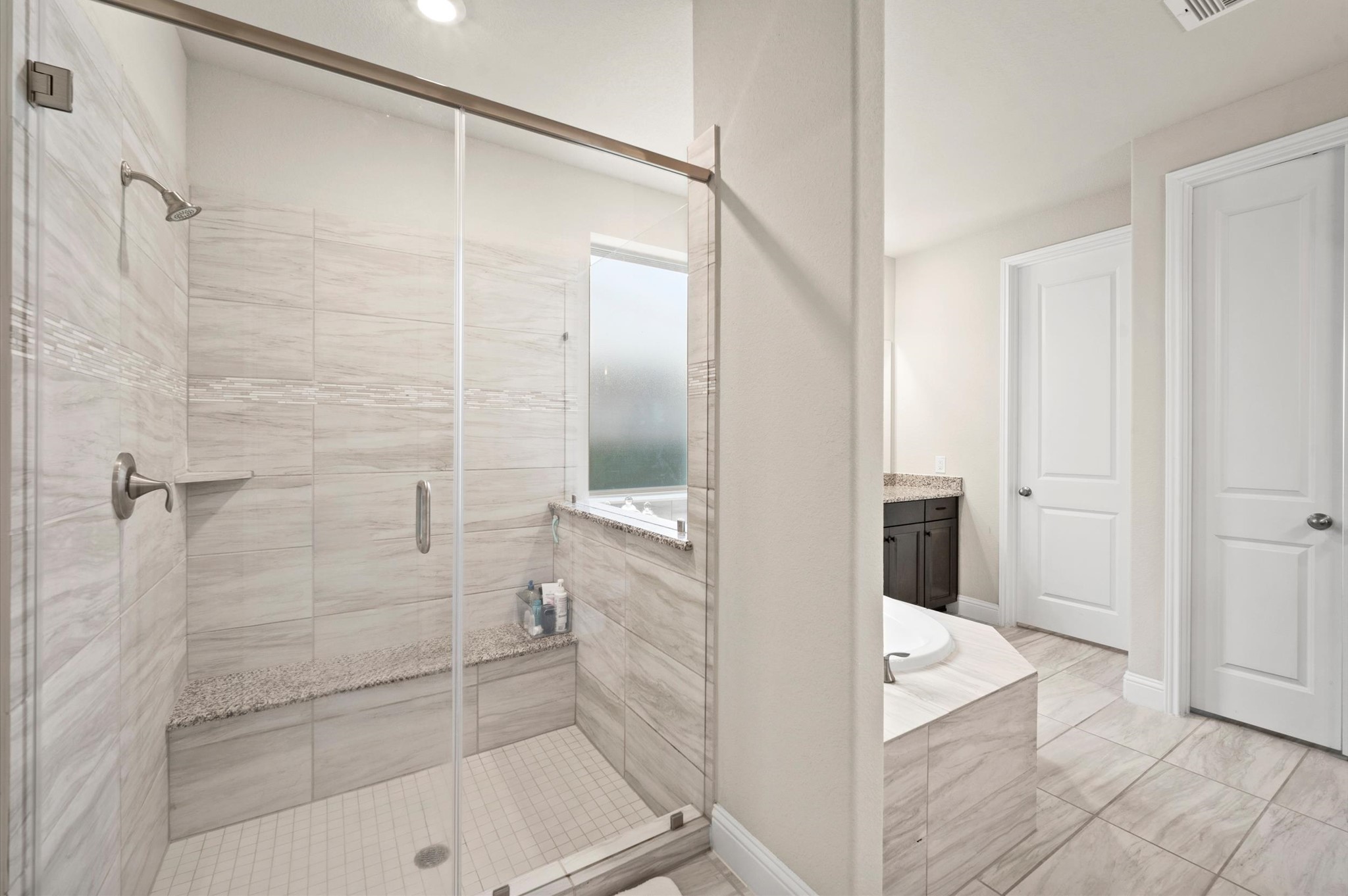 Large walk in shower behind the soaking tub.