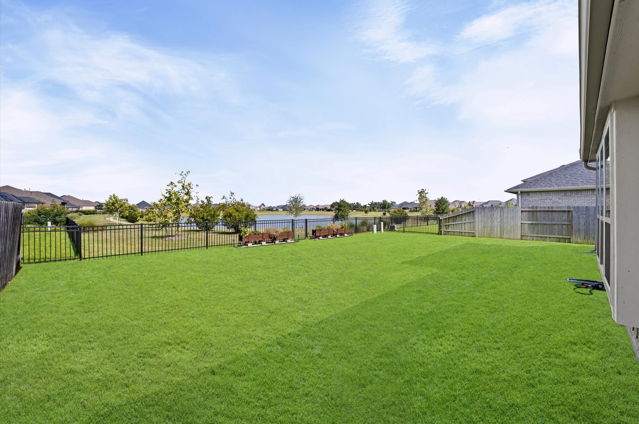 Expansive, lush backyard with serene lake views, and a raised butterfly garden.
