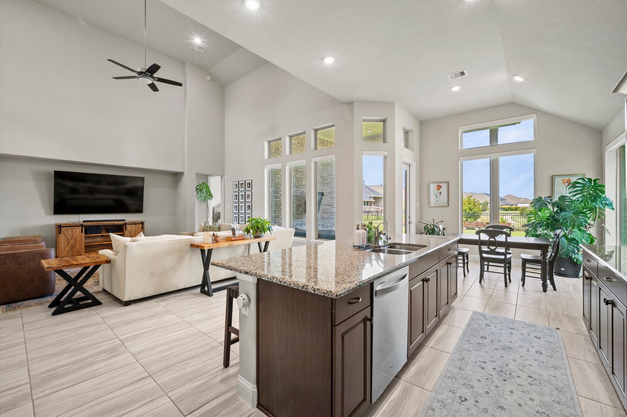 Spacious open-concept living area featuring high ceilings, a modern kitchen with granite countertops, and large windows offering abundant natural light and scenic views.