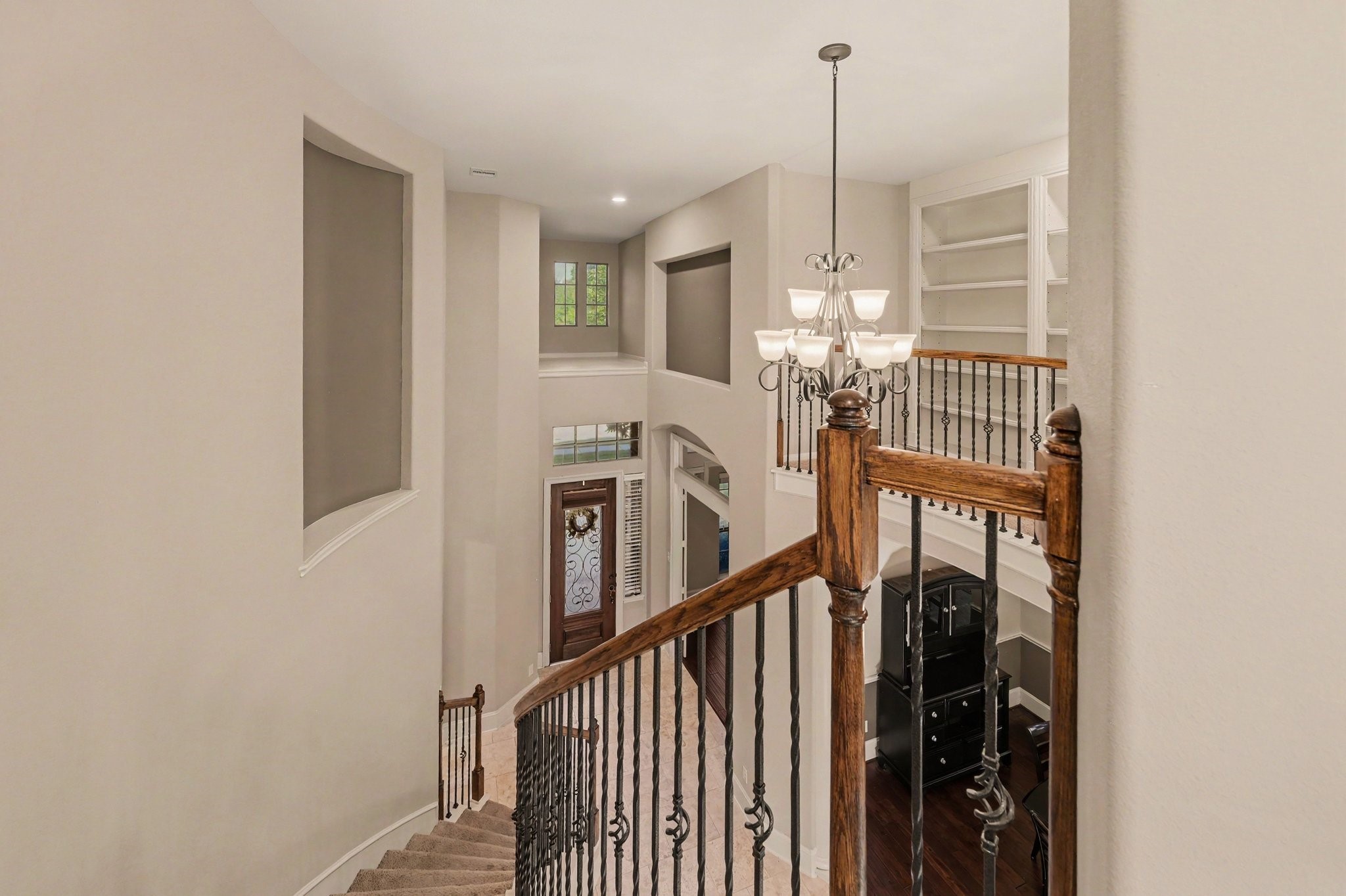 Grand two-story entry featuring a sweeping curved staircase, elegant wrought-iron railings, and soaring ceilings.