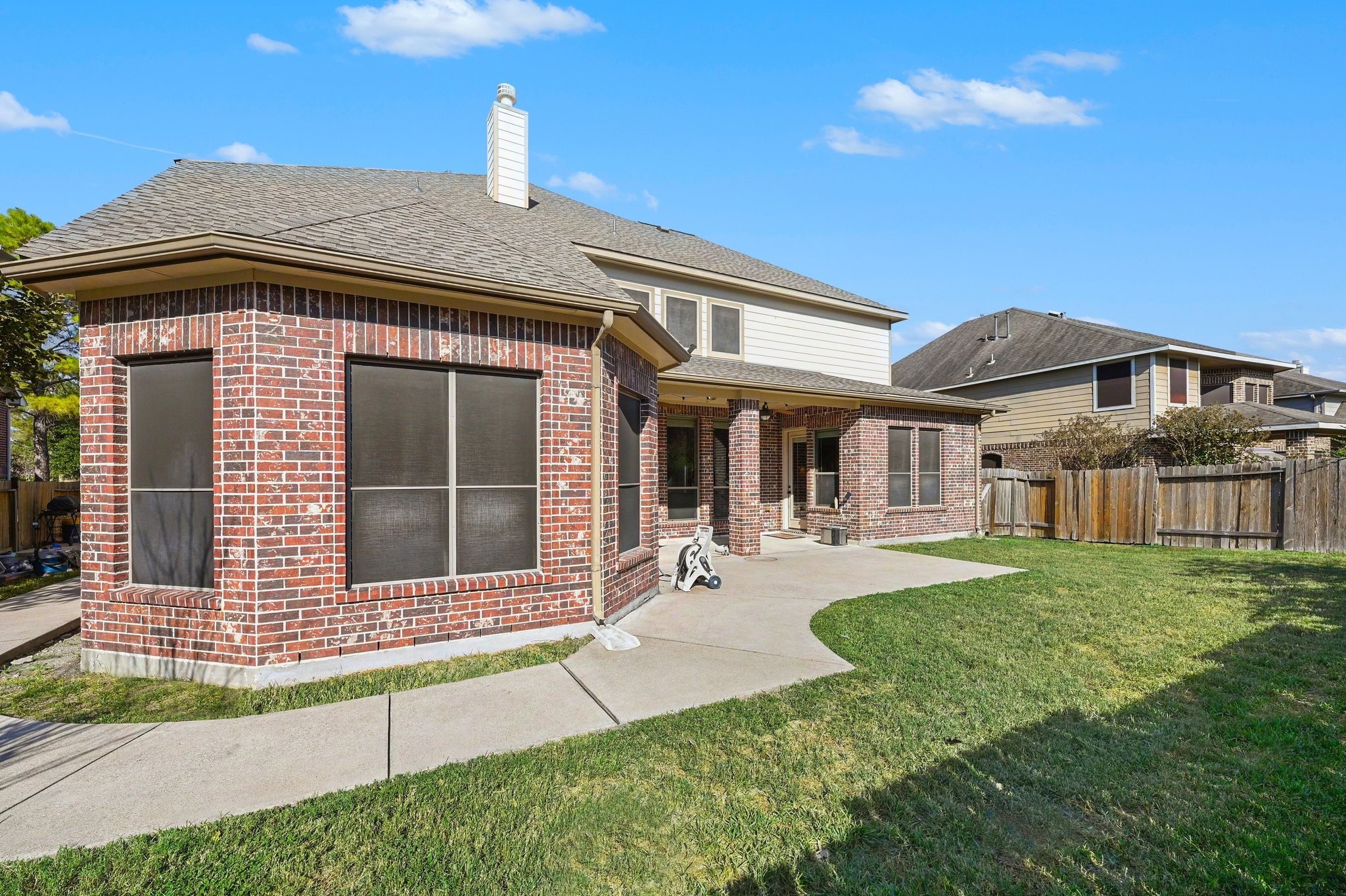 The backyard with a large covered patio, perfect for outdoor dining, entertaining, or relaxing.