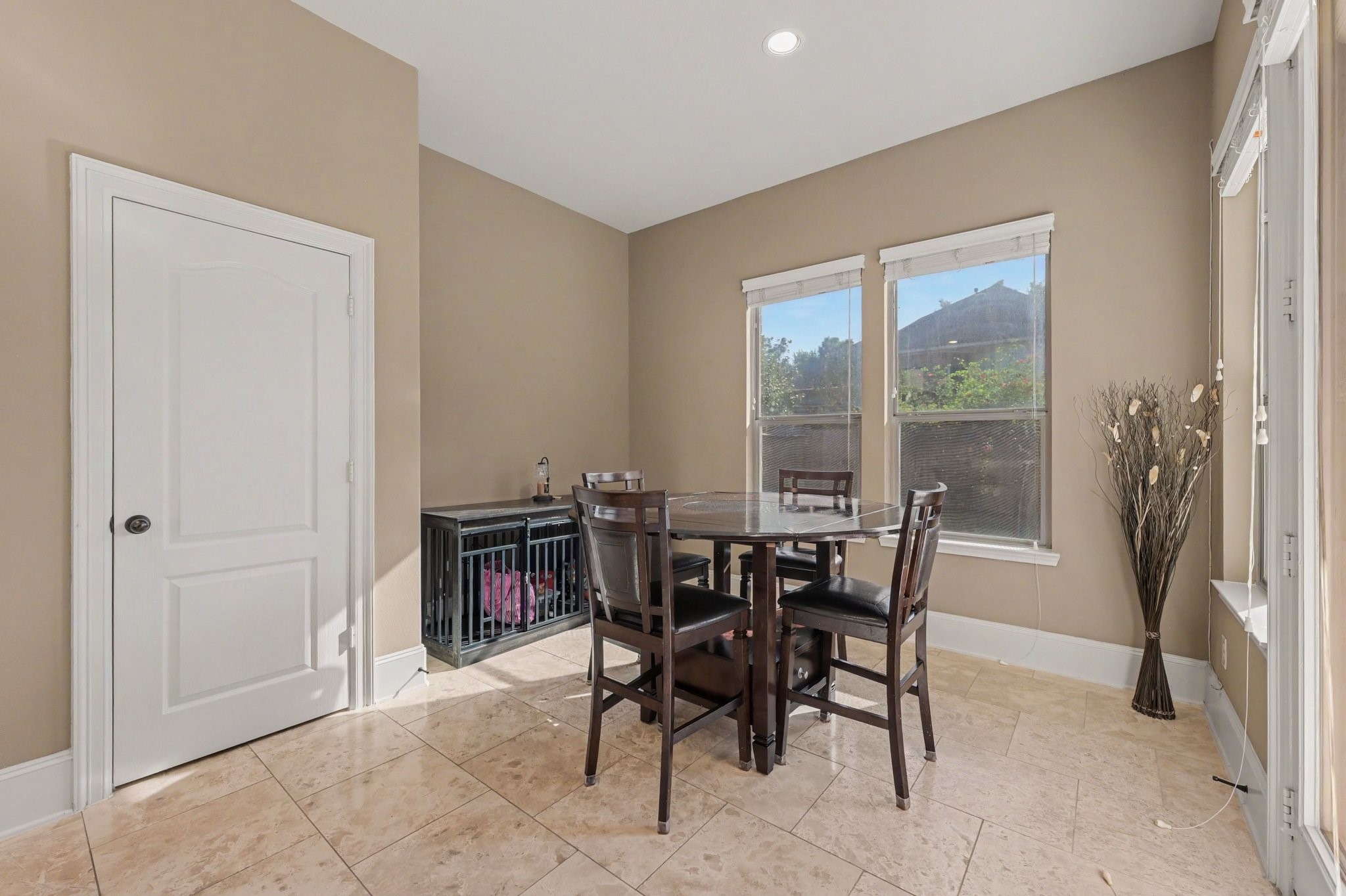 Bright and inviting breakfast nook with large windows overlooking the backyard.
