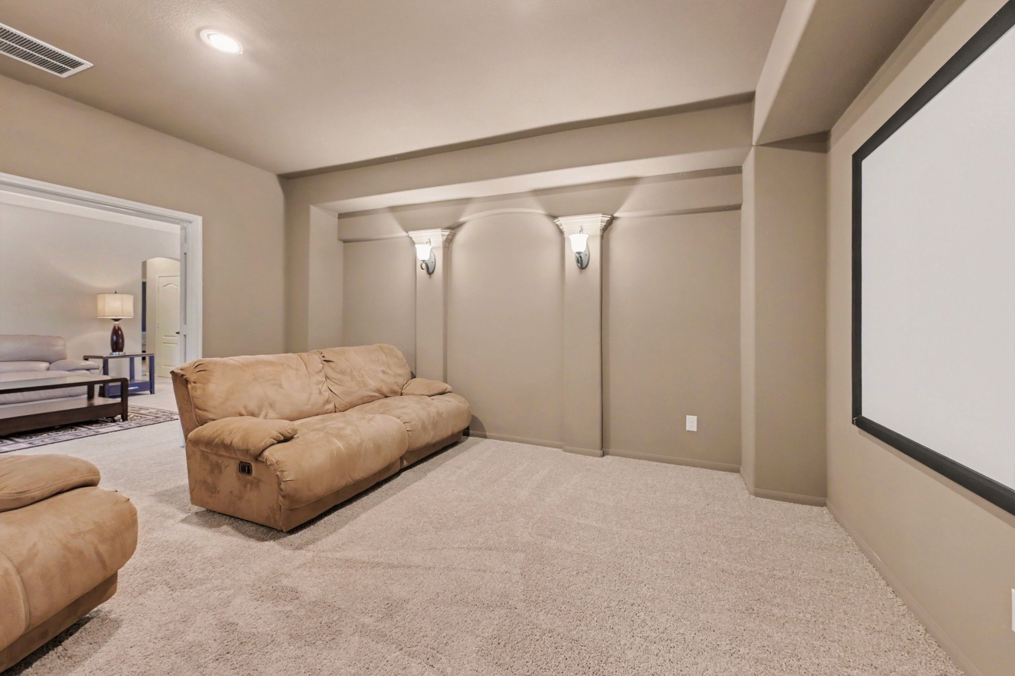 Dedicated upstairs media room with a large projection screen, perfect for movie nights and entertainment.