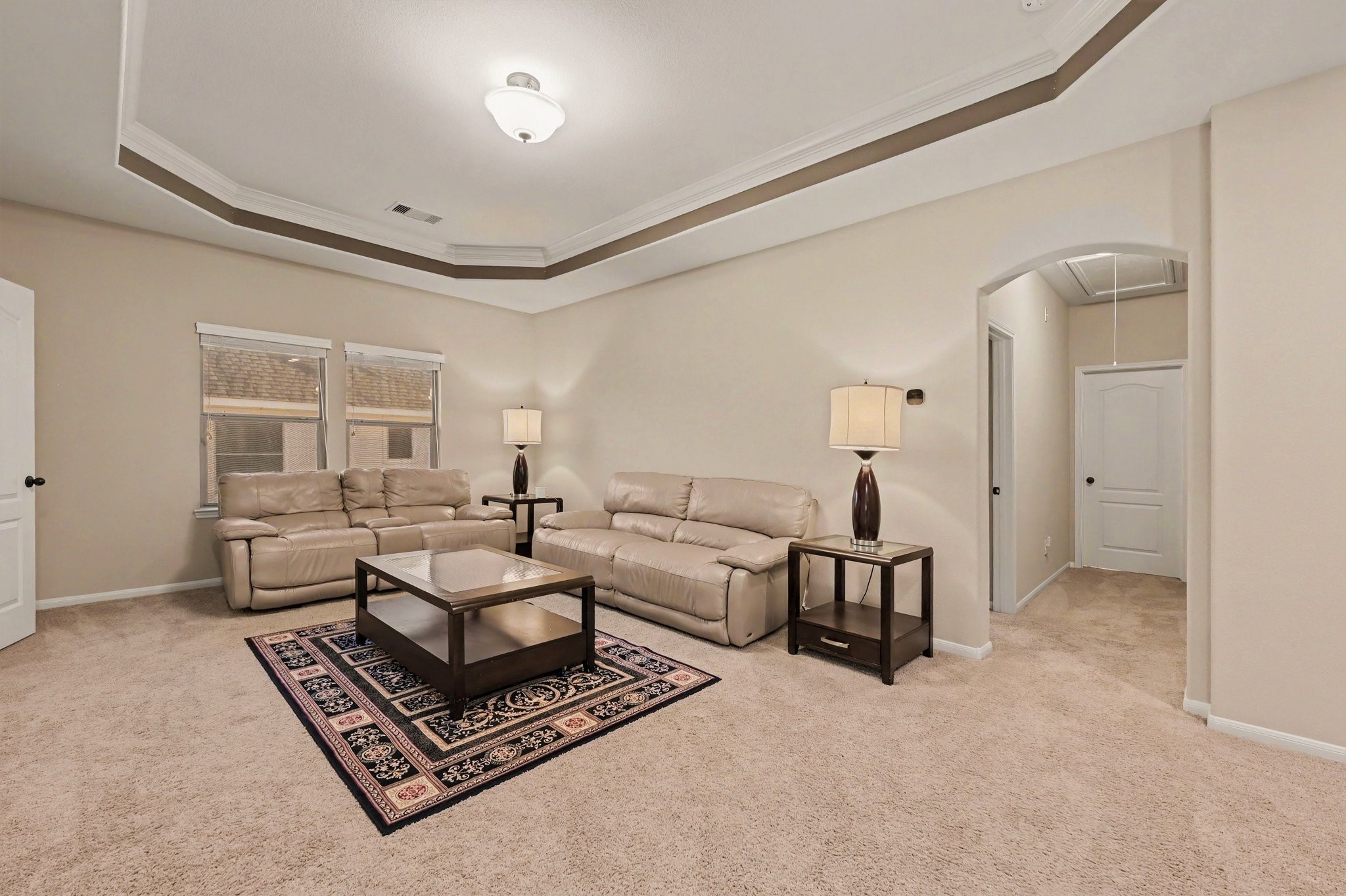 Spacious upstairs family room with an elegant tray ceiling, offering a comfortable space to relax or entertain.