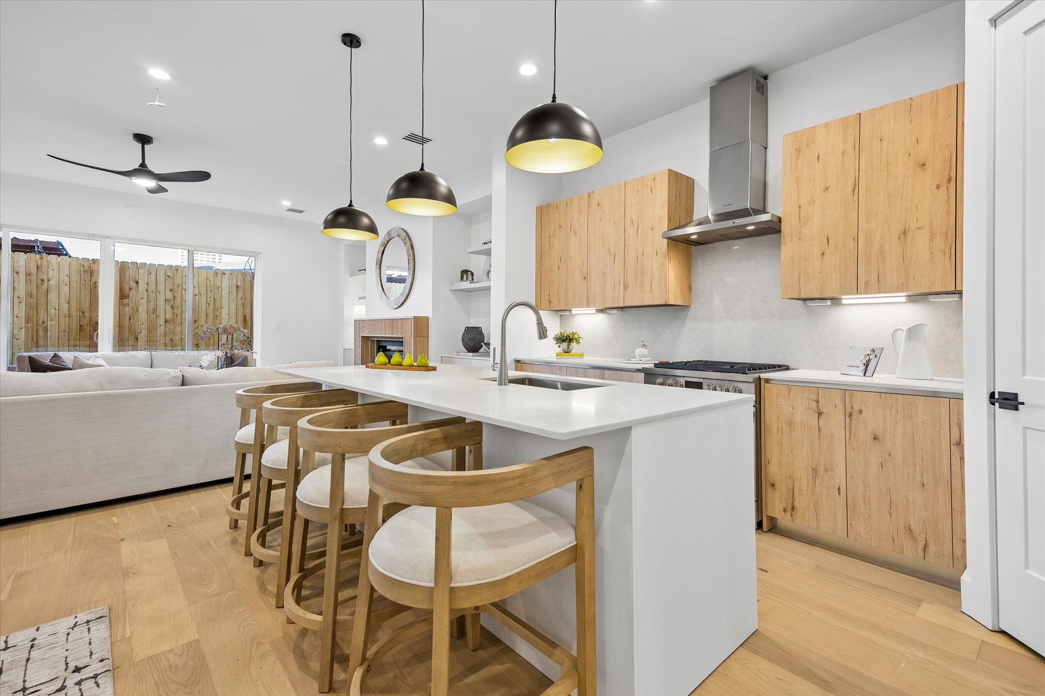 Gorgeous kitchen features beautiful quartz countertops & backsplash, large center island w/ oversized stainless steel sink, breakfast bar seating & 3 contemporary black pendant lights. Light wood-toned cabinetry, recessed lighting & open views to the living and dining areas make this the heart of the home!