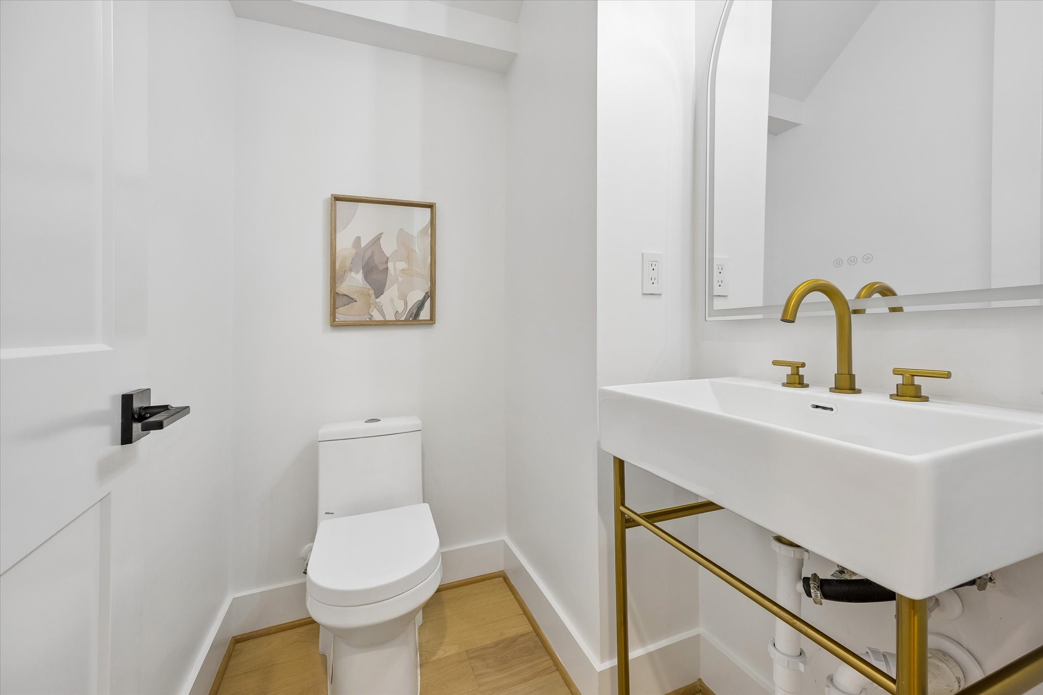 Convenient first-floor powder bath located just off the entry! Features a beautiful contemporary vanity with decorative brass-toned base, modern fixtures & recessed lighting. Perfectly positioned for guests while entertaining in the open-concept living and dining areas.