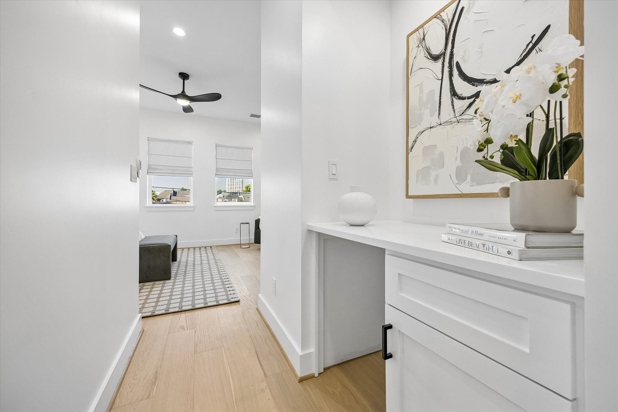 Upon entering the primary suite is a built-in desk/counter area with cabinetry offers additional functionality, with plumbing available for a potential beverage refrigerator or sink; makes an ideal coffee bar!