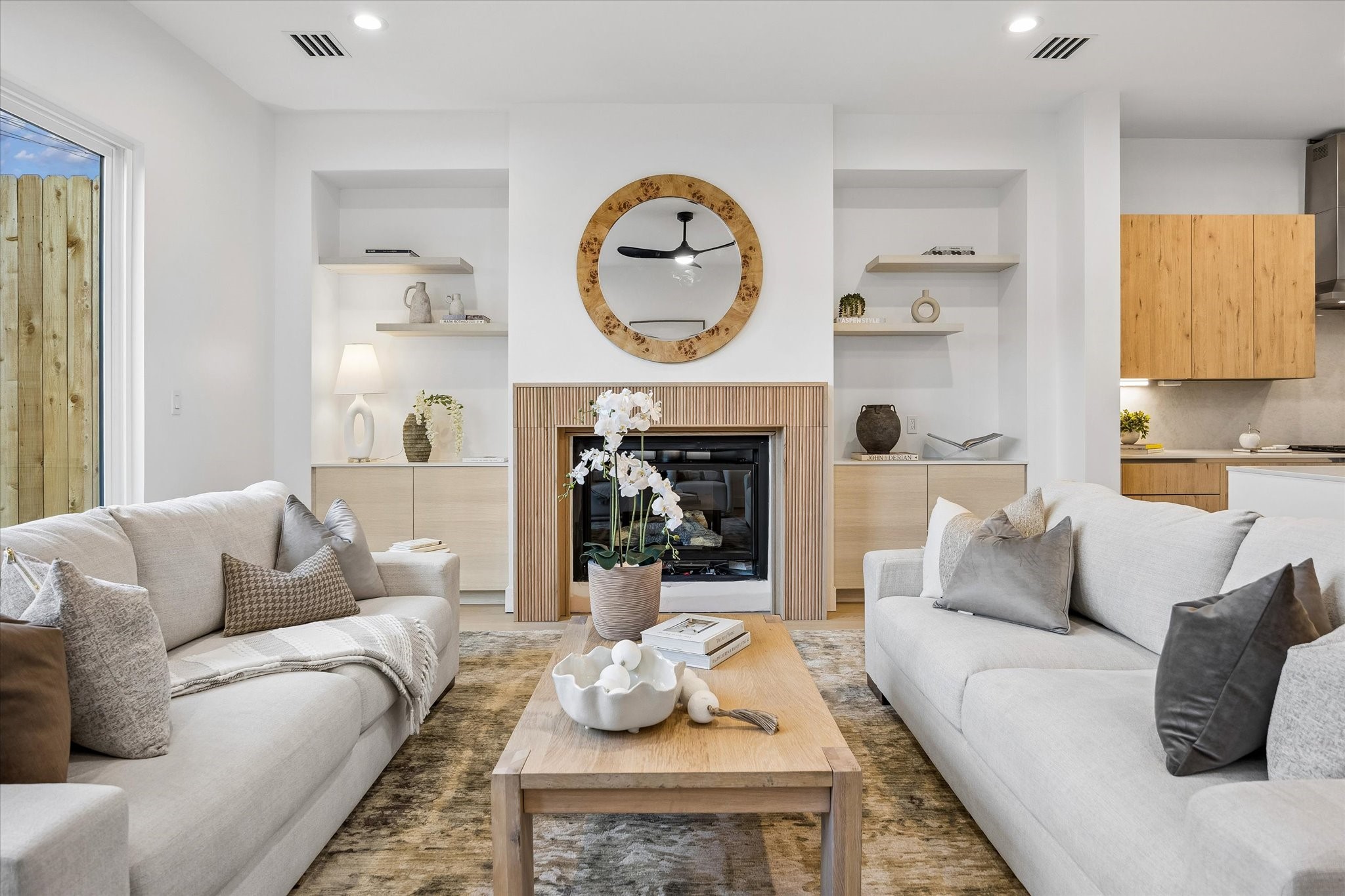 The beautiful family room features a gas-log fireplace w/ decorative beadboard surround, built-in cabinetry on both sides & floating display shelves above. Modern ceiling fan, recessed lighting & large sliding glass doors provide abundant natural light and convenient access to the private backyard.