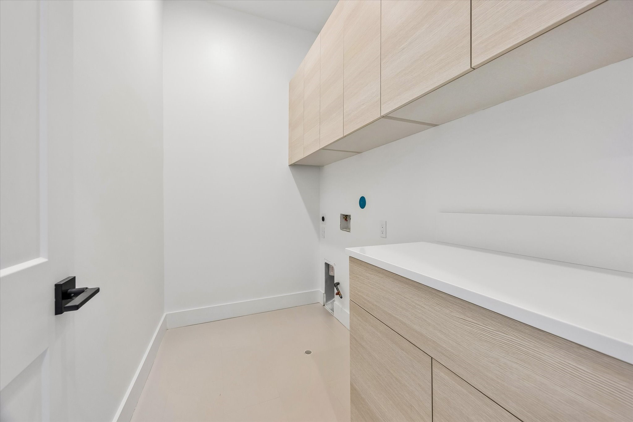 Convenient second-floor utility room located near the primary suite & secondary bedroom! Features quartz countertop with folding space, light wood-toned cabinetry, storage drawers & upper cabinets. Equipped with washer connections and both gas & electric dryer connections for added flexibility.