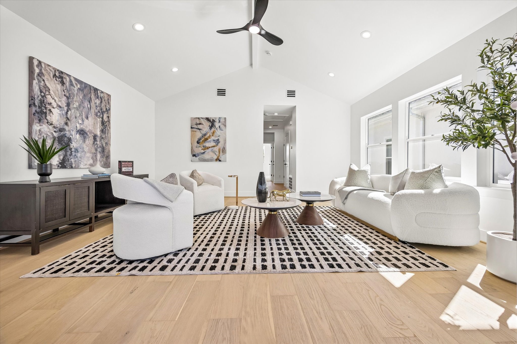 Another look at the spacious third-floor gameroom highlighting the soaring vaulted ceiling, abundant natural light & wonderful flexible layout. Plenty of room for large furnishings, with an electrical outlet positioned for a future wall-mounted TV. Sliding glass doors create seamless indoor/outdoor living with access to the covered terrace!
