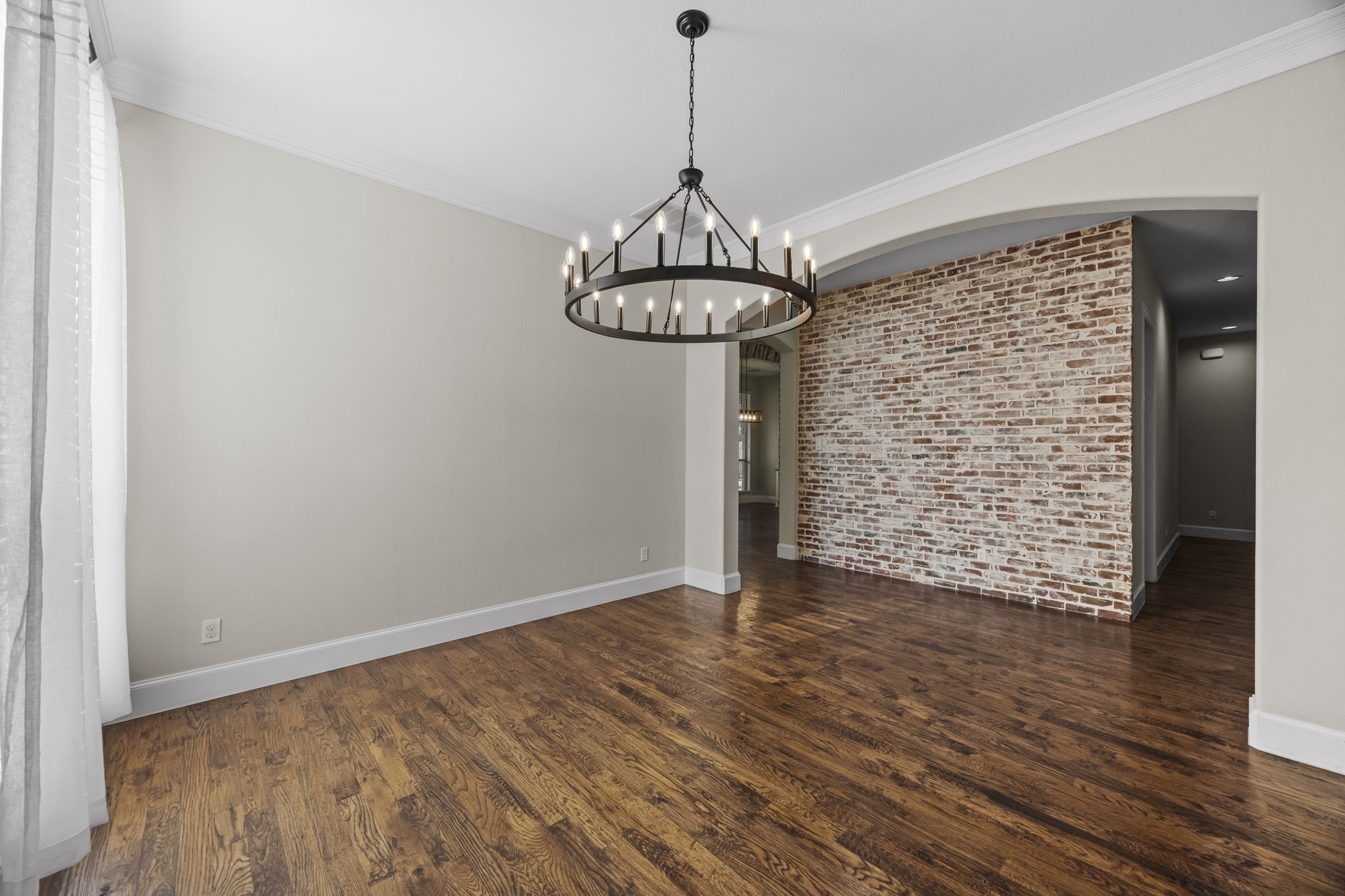 View of Dining Room peering into the Hallway highlighted by the brick accent wall.