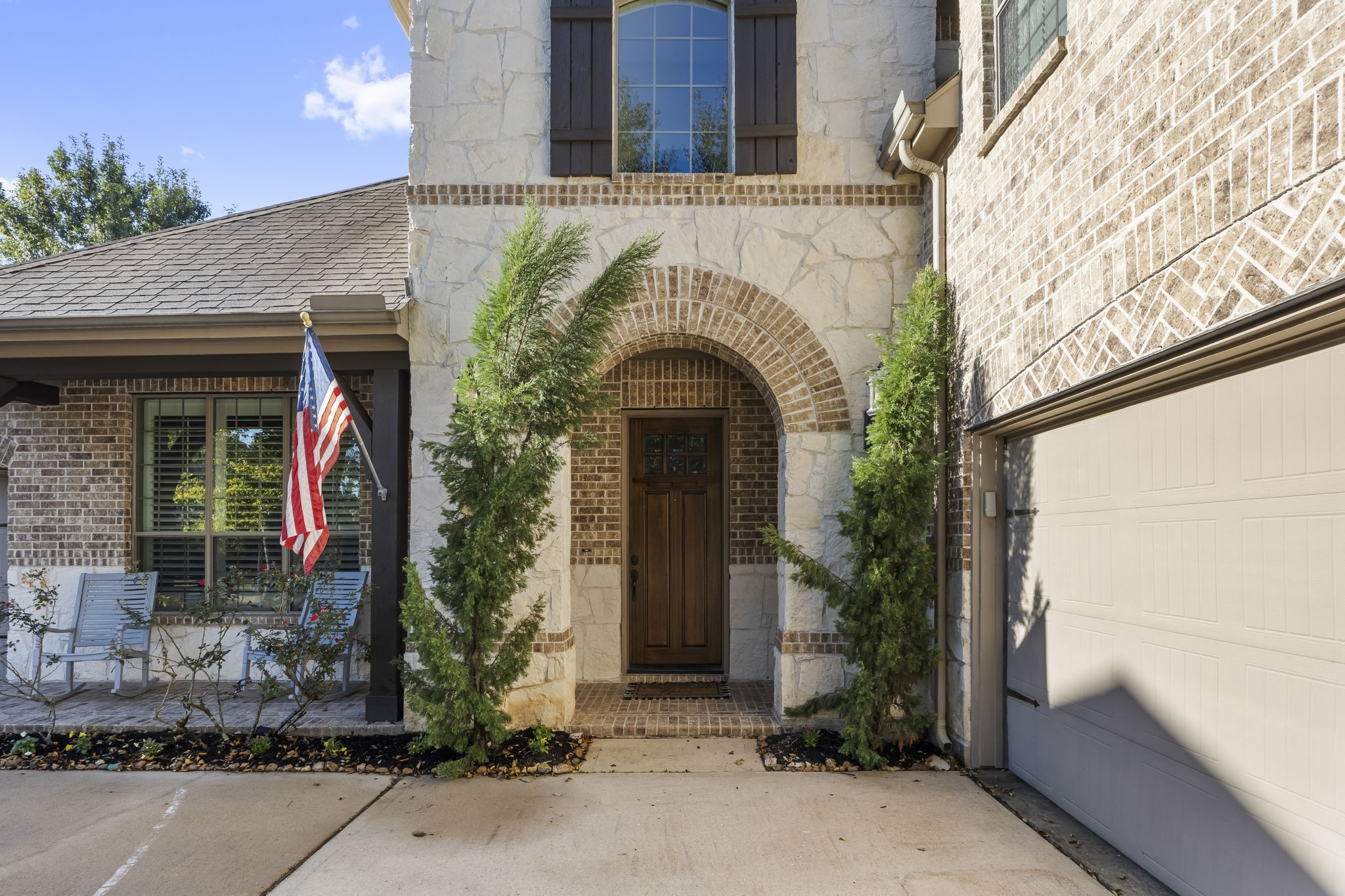 Handsome curb appeal is highlighted by mature trees, stone and brick elevation capped off with wood cedar accents