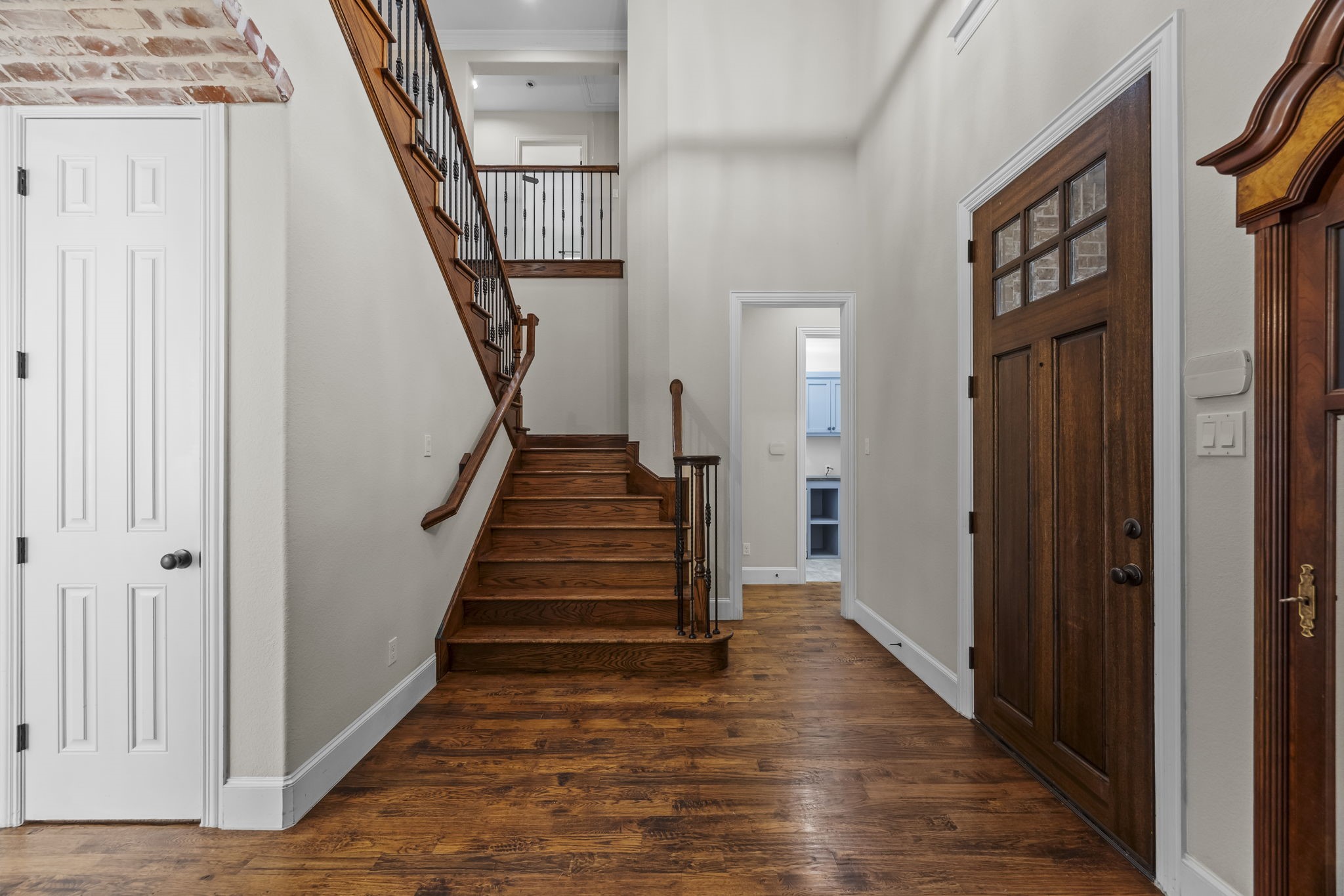 Foyer greets you with soaring ceilings, rich wood flooring, and fresh interior painted walls.