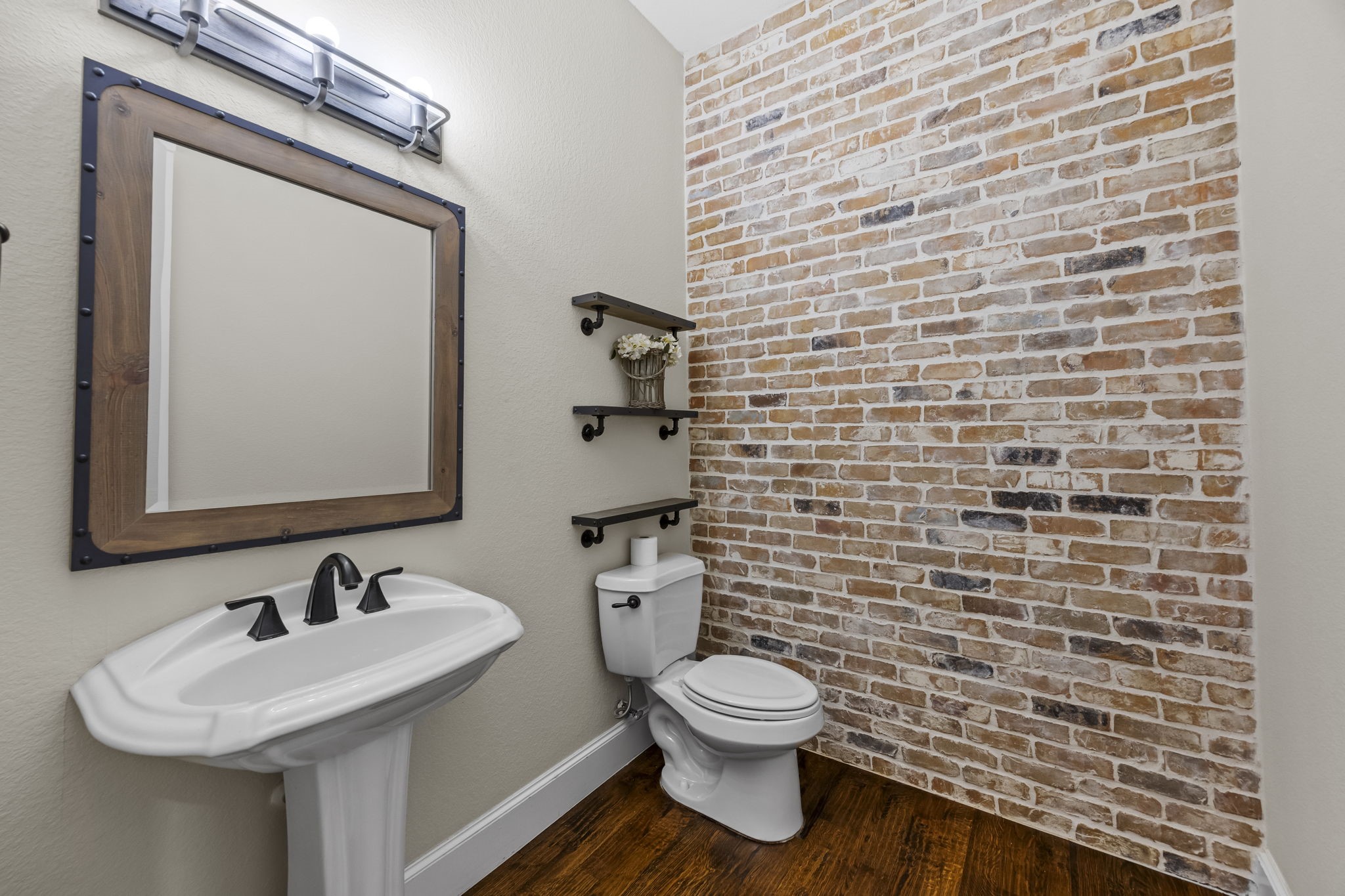 Even the hallway half bathroom handsome featuring this brick accent wall
