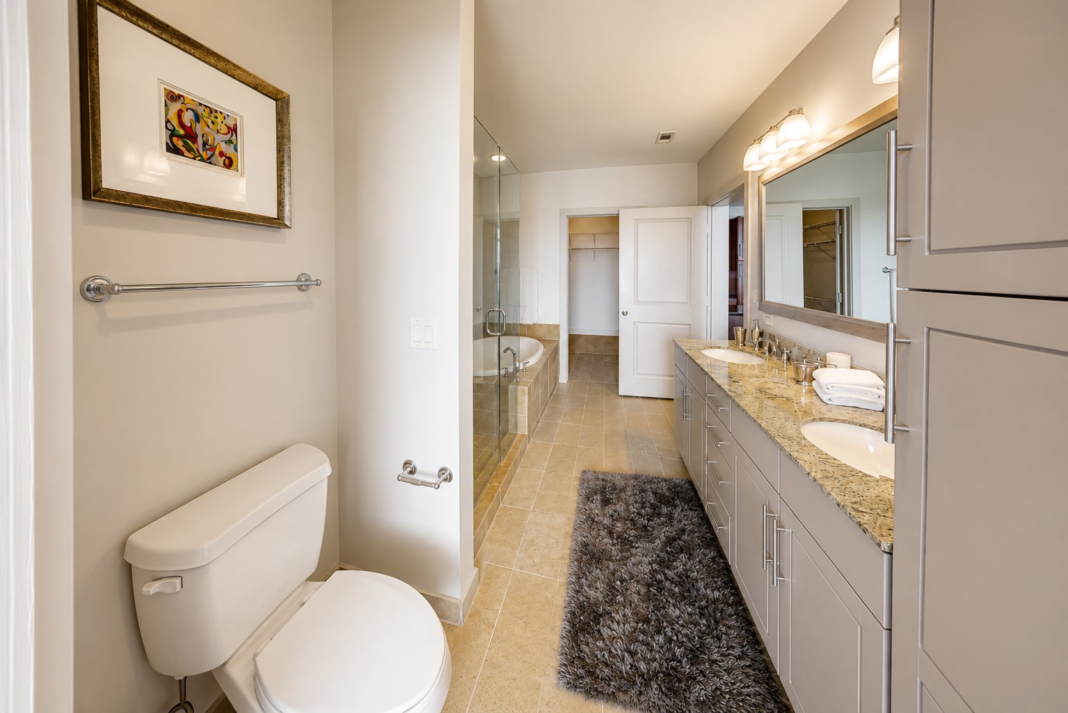 Well-appointed primary bath offers an expansive dual-sink vanity, lots of drawers, linen closets, generous storage, granite countertops and direct access to the spacious walk-in closet.