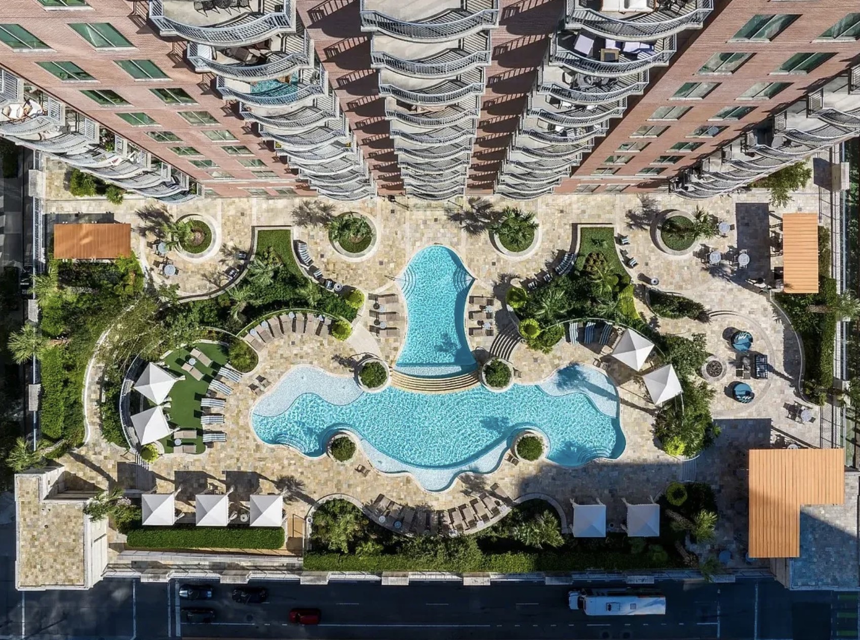 From above, the resort-style pool deck showcases an impressive outdoor oasis thoughtfully designed for relaxation and recreation. Surrounded by lush landscaping, private cabanas, outdoor kitchen, lounge areas and elegant gathering spaces. Offering an upscale atmosphere reminiscent of a luxury resort experience.