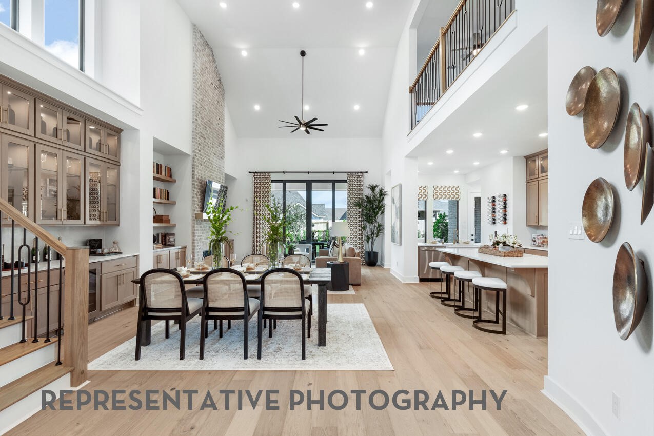 Open dining area seamlessly connected to the kitchen and family room beneath soaring ceilings.