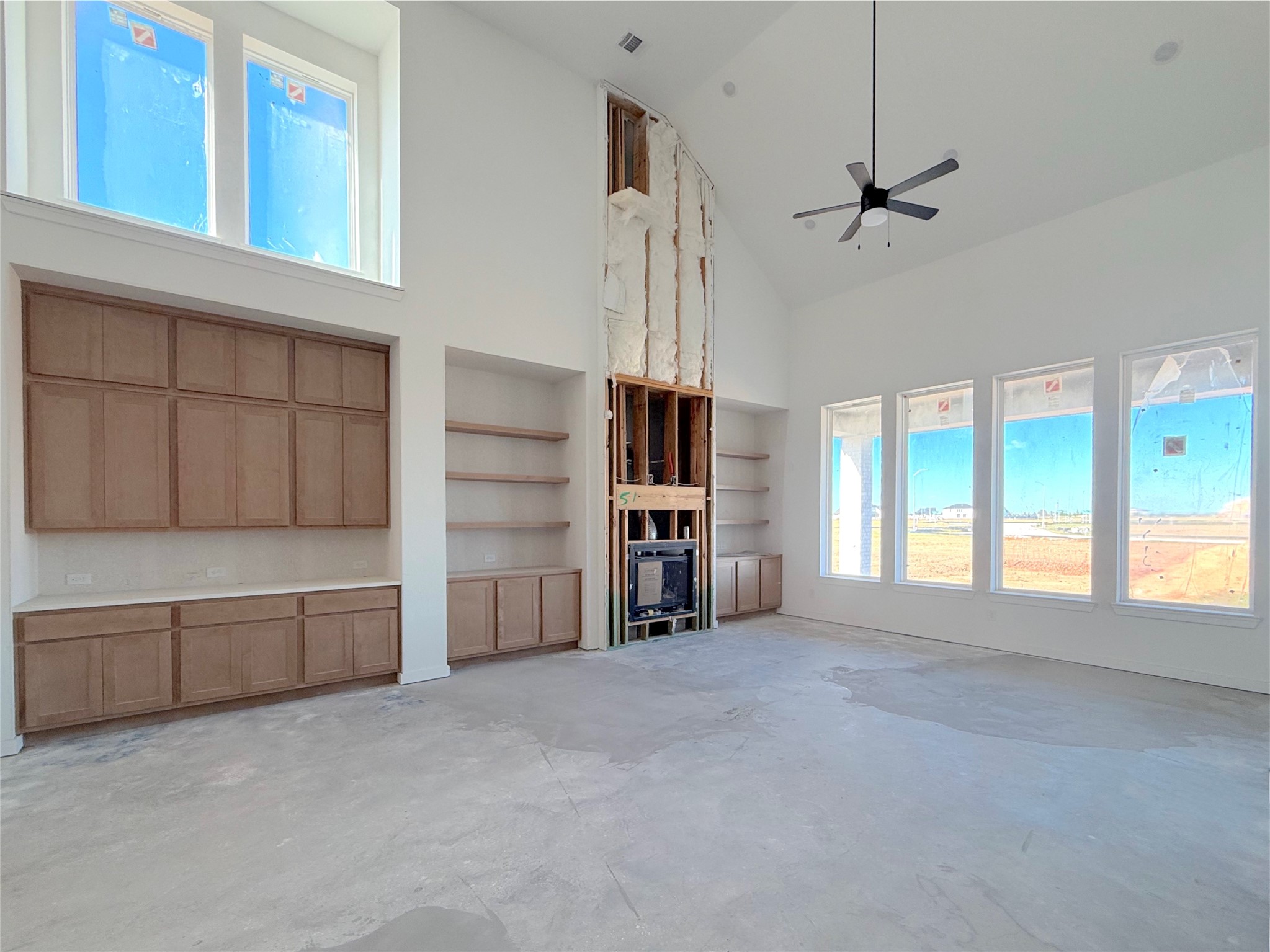 Light filled family room showcasing a fireplace with built in surround and open views of the main living spaces