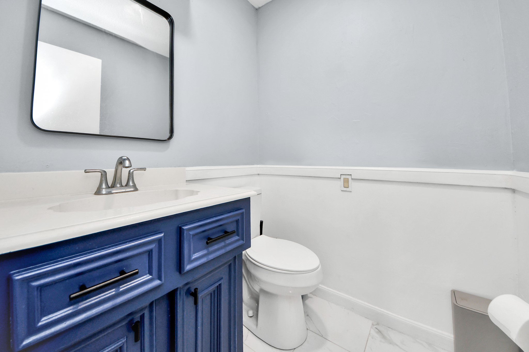 A brilliant splash of designer personality. A striking blue vanity pops beautifully against a pristine, light background, offering a memorable and upscale presentation for visiting guests.