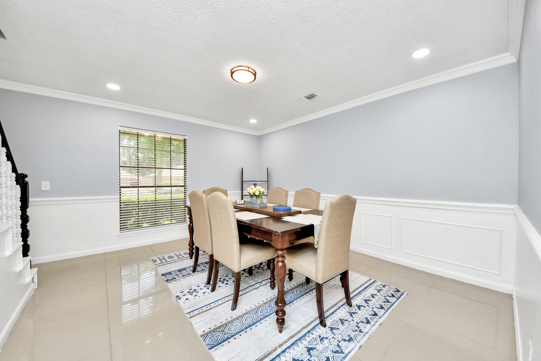 Intricate wainscoting and crown molding frame this elegant dining space, wrapped in a light palette that elevates every dinner party.