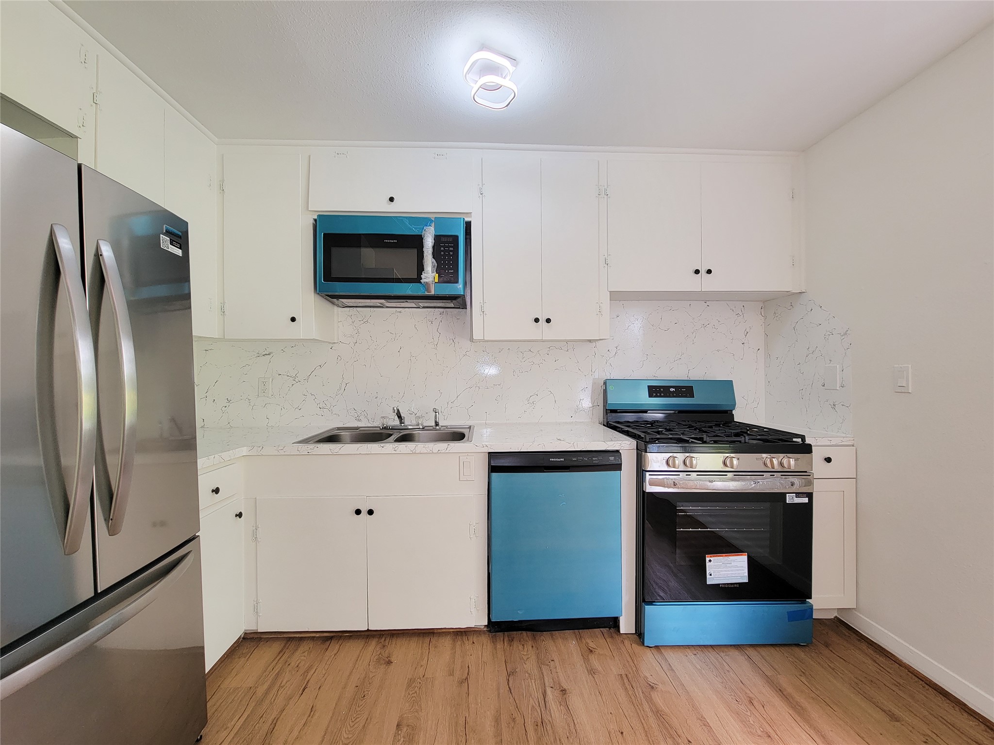 Experience contemporary charm and functionality in this modern kitchen, featuring stainless steel appliances, sleek cabinetry, and a stylish backsplash.