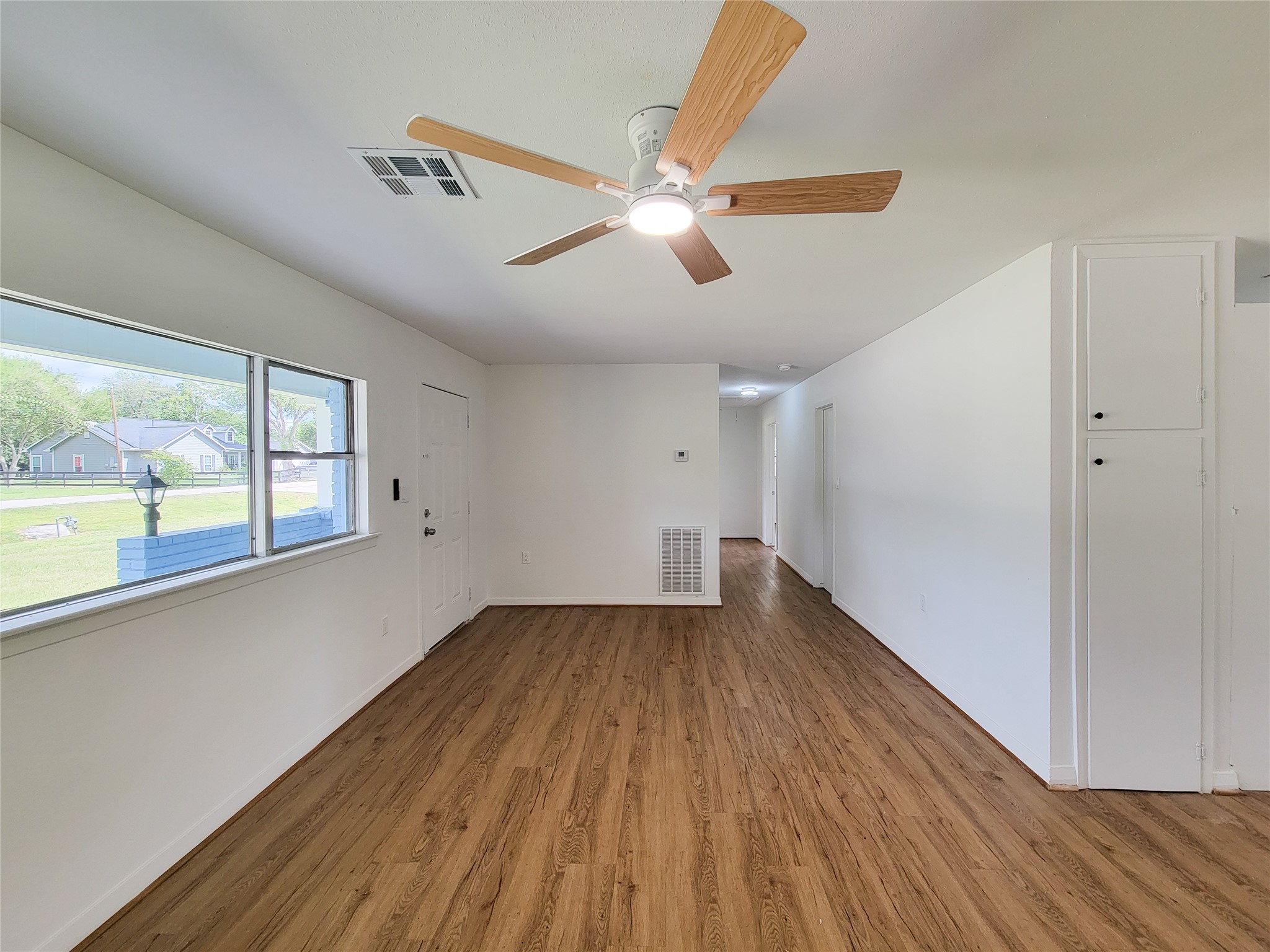 Experience the perfect blend of modern elegance and comfort in this bright, airy living space, showcasing sleek hardwood floors, a stylish ceiling fan, and large windows that flood the room with natural light. Experience the perfect blend of modern elegance and comfort in this bright, airy living space, showcasing sleek hardwood floors, a stylish ceiling fan, and large windows that flood the room with natural light.