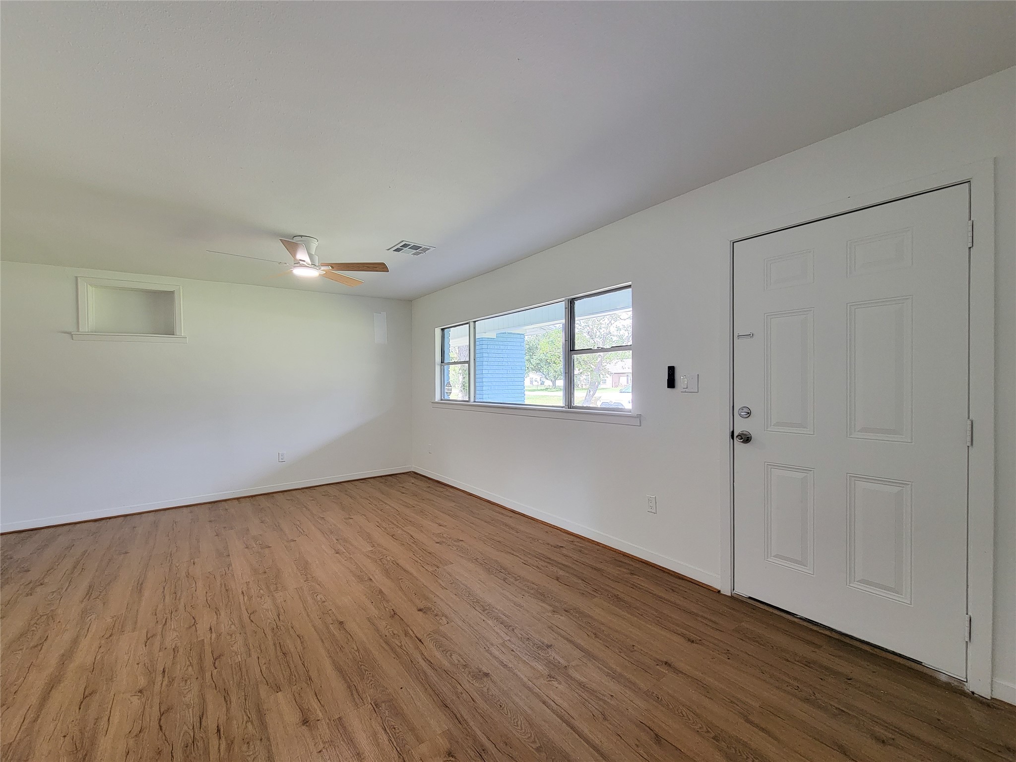 Experience the perfect blend of elegance and comfort in this bright and airy living space, featuring stylish wood flooring, abundant natural light from large windows, and a sleek modern ceiling fan. Experience the perfect blend of elegance and comfort in this bright and airy living space, featuring stylish wood flooring, abundant natural light from large windows, and a sleek modern ceiling fan.