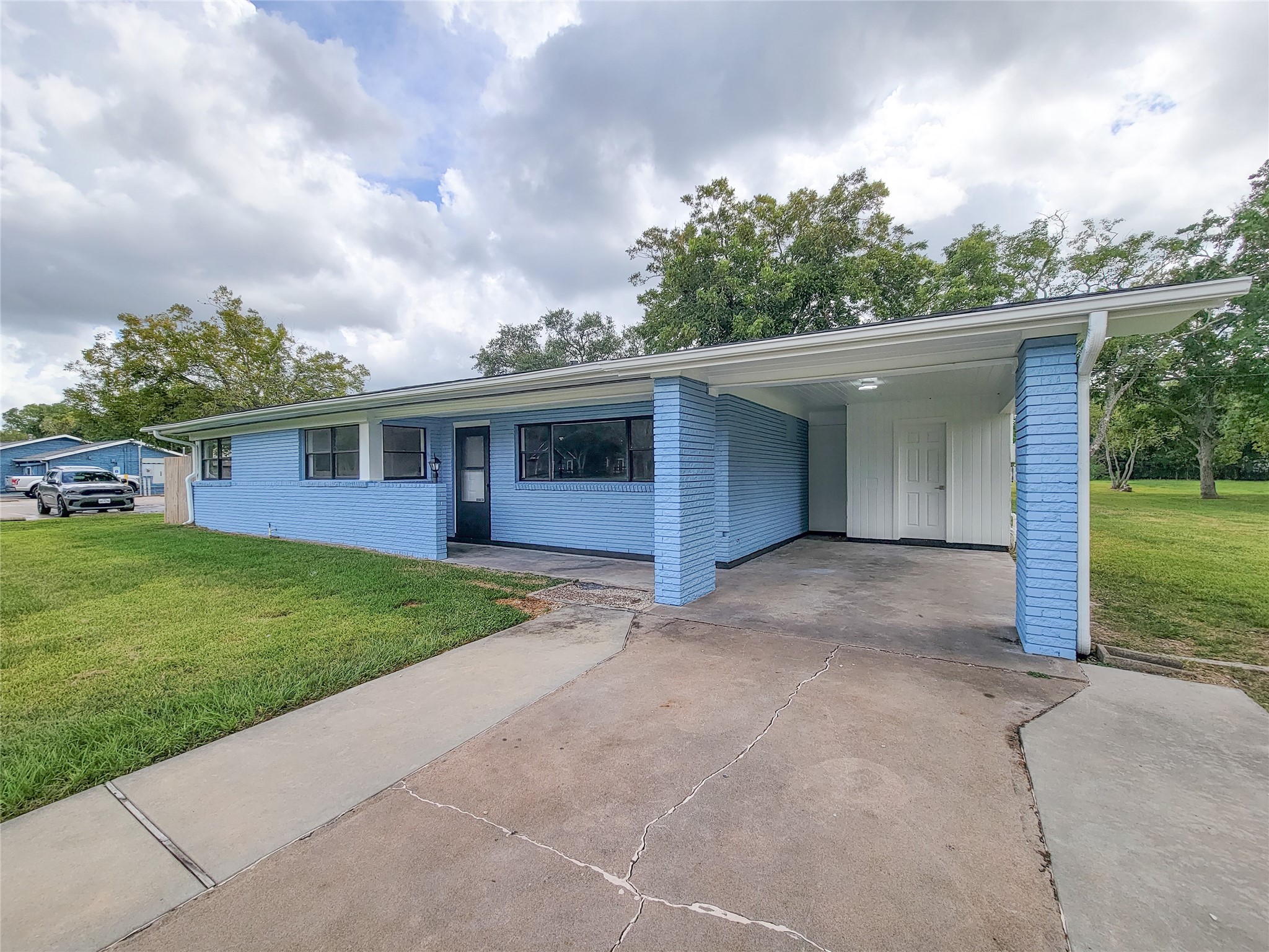Charming blue brick home with a spacious carport, nestled on a lush green lawn and surrounded by mature trees, offering serene and picturesque living. Charming blue brick home with a spacious carport, nestled on a lush green lawn and surrounded by mature trees, offering serene and picturesque living.