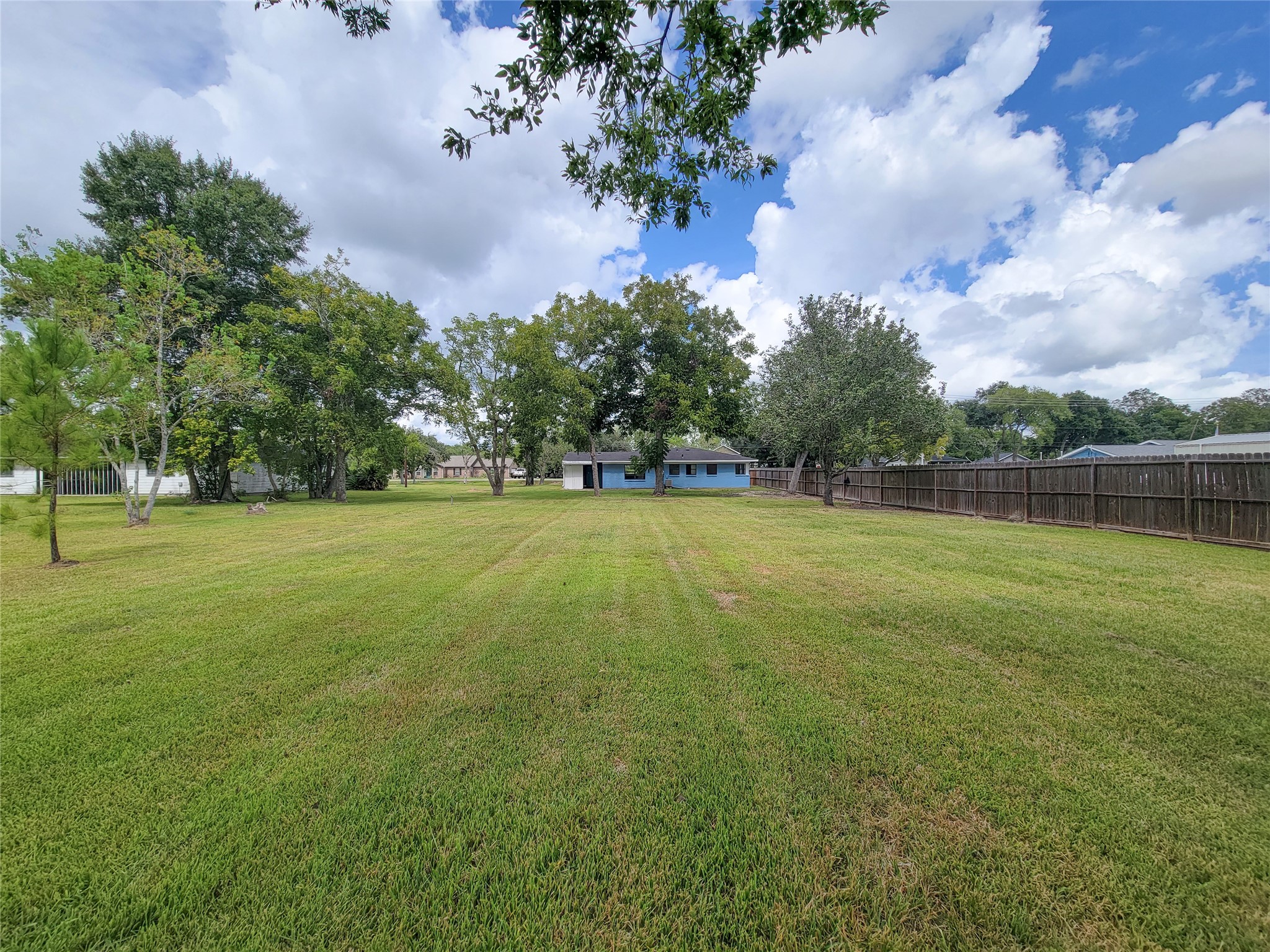 Discover an expansive, lush backyard adorned with mature trees, offering ample space for outdoor activities, perfect for embracing nature and entertaining guests.
