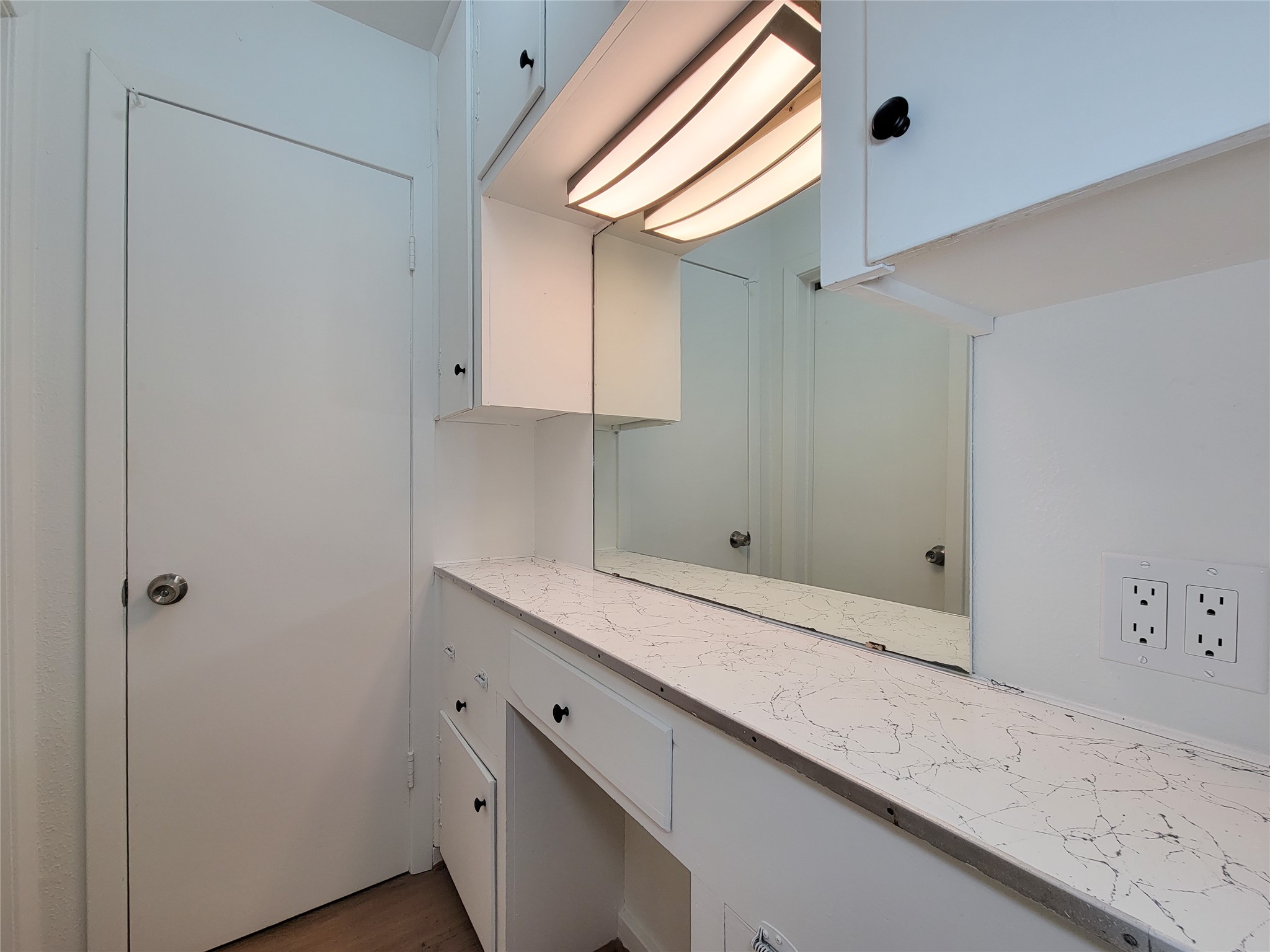 Experience a bright and functional vanity area with sleek countertops, modern lighting, and ample storage for all your needs.