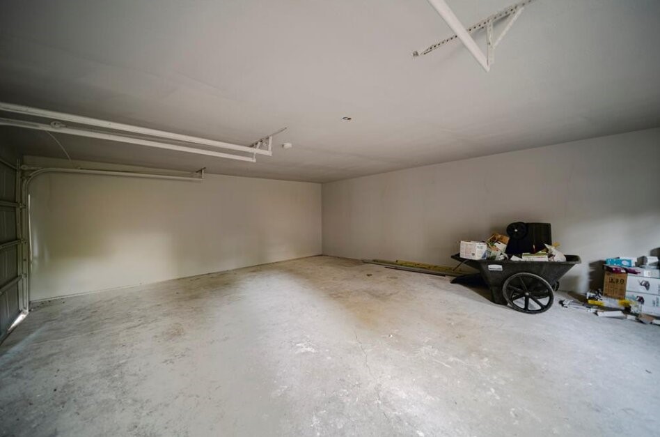 Spacious garage with concrete flooring, neutral walls, and overhead door.
