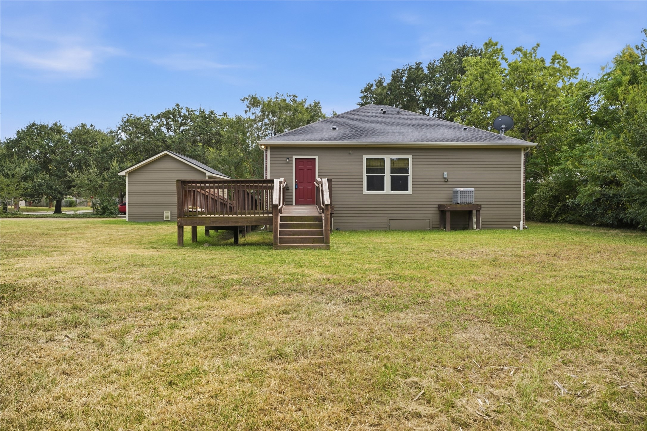 A small landing at the back door connects to the access ramp and steps leading into the backyard.
