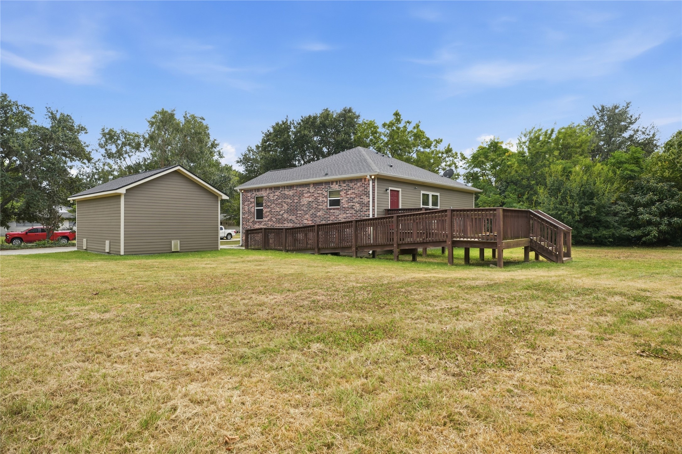This backyard view shows the detached garage and the access ramp connecting to the rear deck, offering an alternative to the steps.