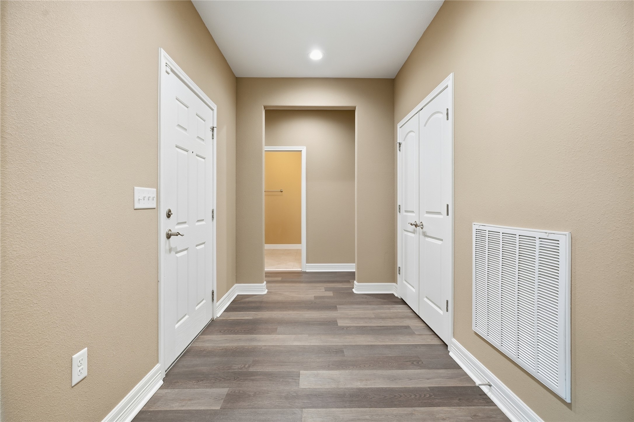 The entryway includes a double-door closet for coats and storage, with a wide opening leading to the hallway.