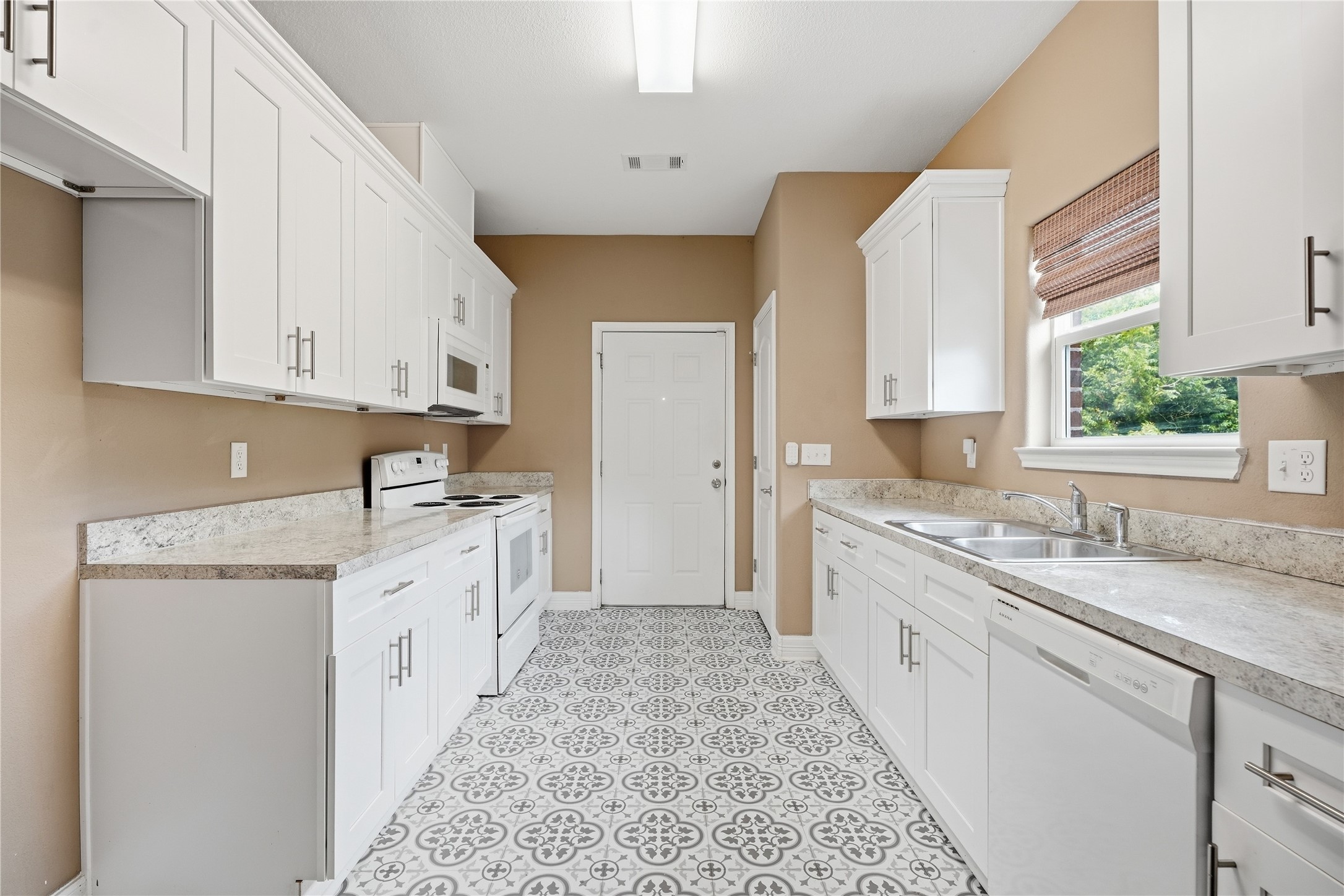 White cabinetry and generous counter space give the kitchen plenty of room for meal prep and storage.