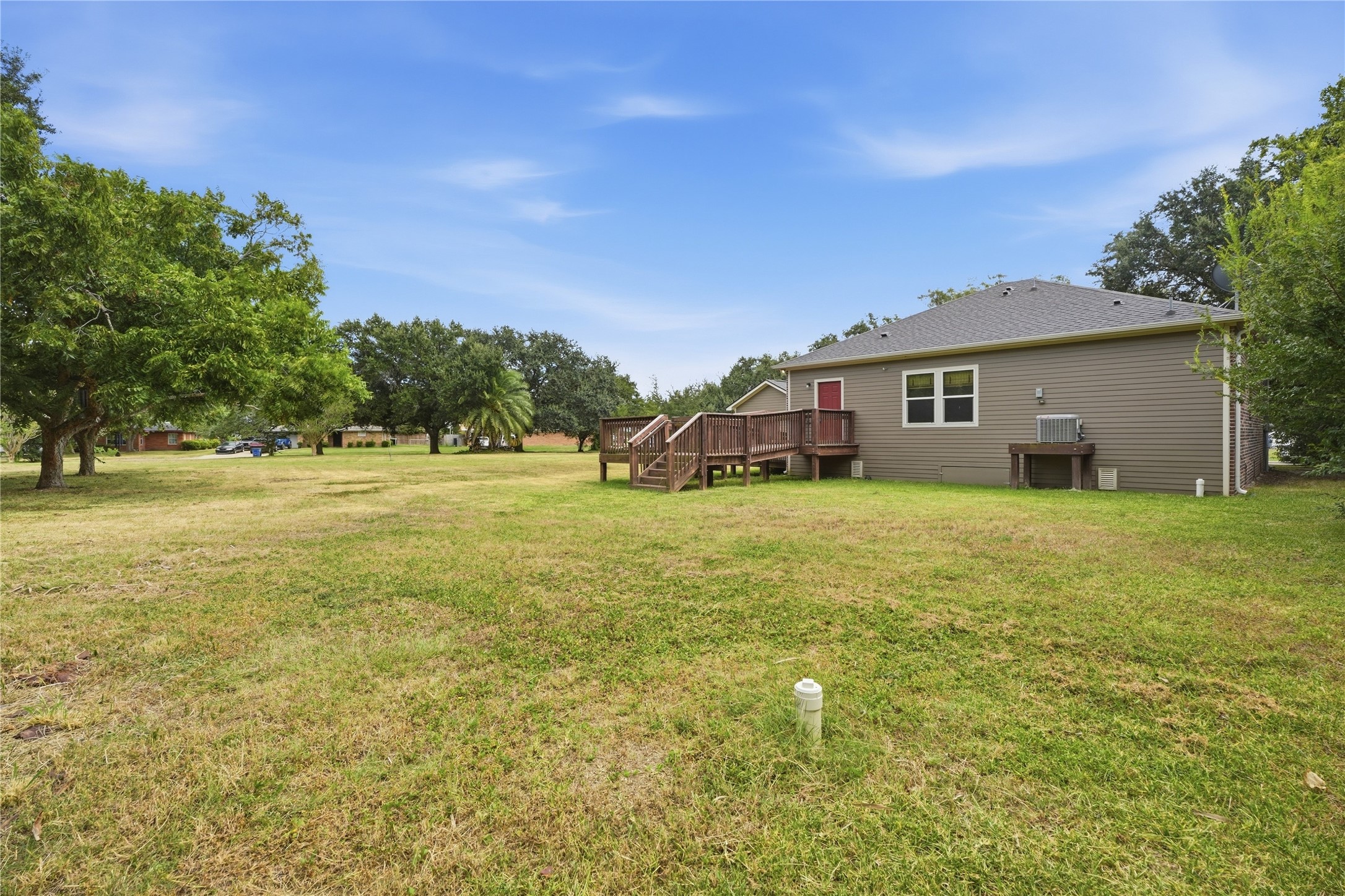 The backyard offers plenty of open space, with steps and an access ramp connecting to the small landing at the back door.
