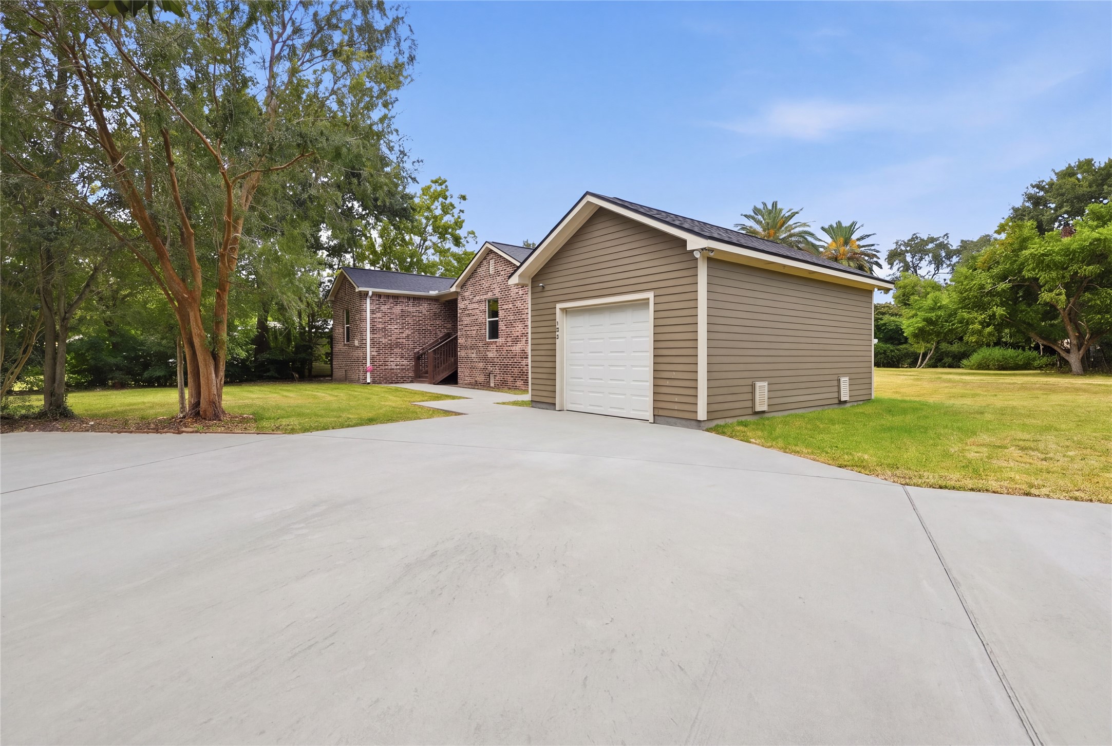 A spacious yard with mature trees and room for gardening or outdoor activities alongside the detached garage.
