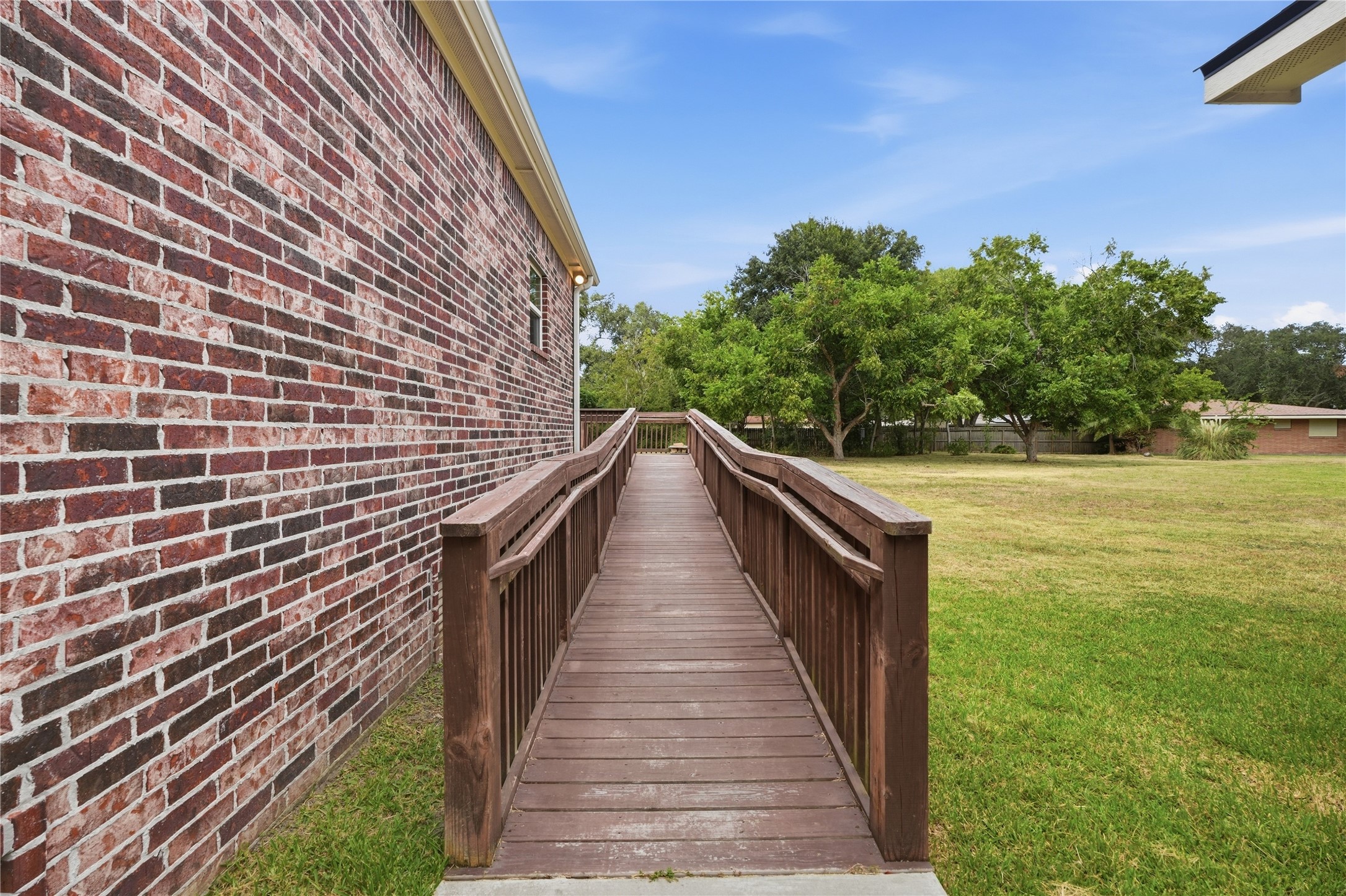 An access ramp with handrails on both sides leads to the back entrance, providing an alternative to the steps.