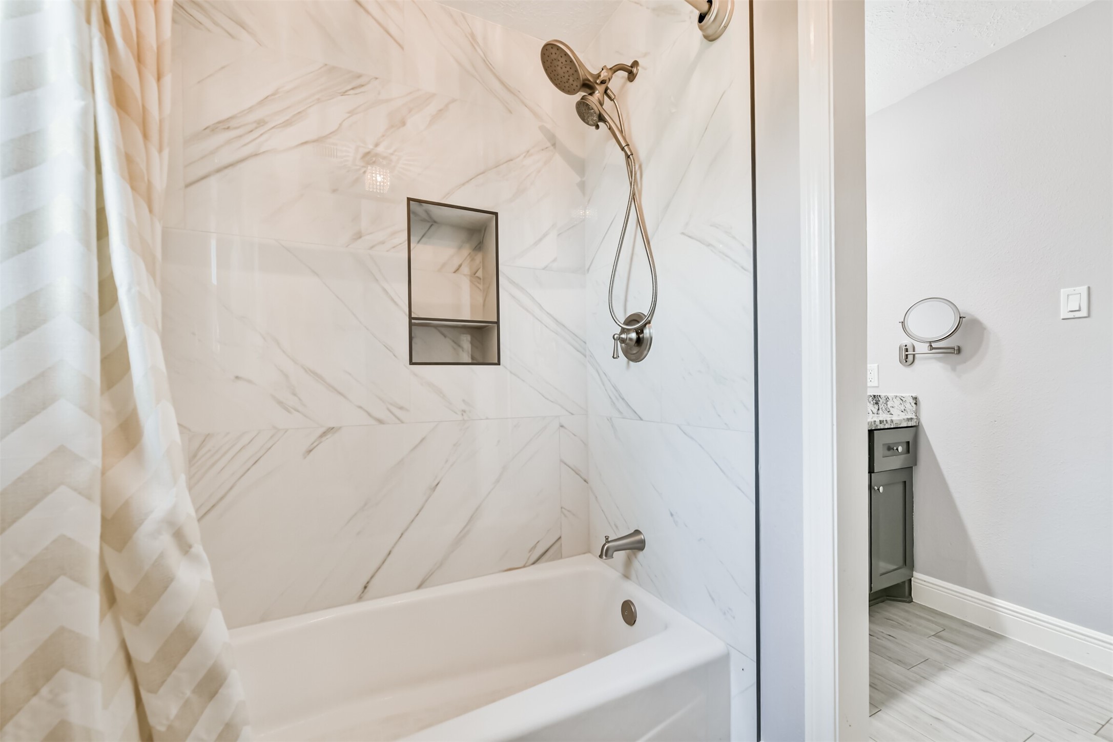 Luxurious full bath featuring elegant marble-style tiles and modern fixtures for a spa-like experience.