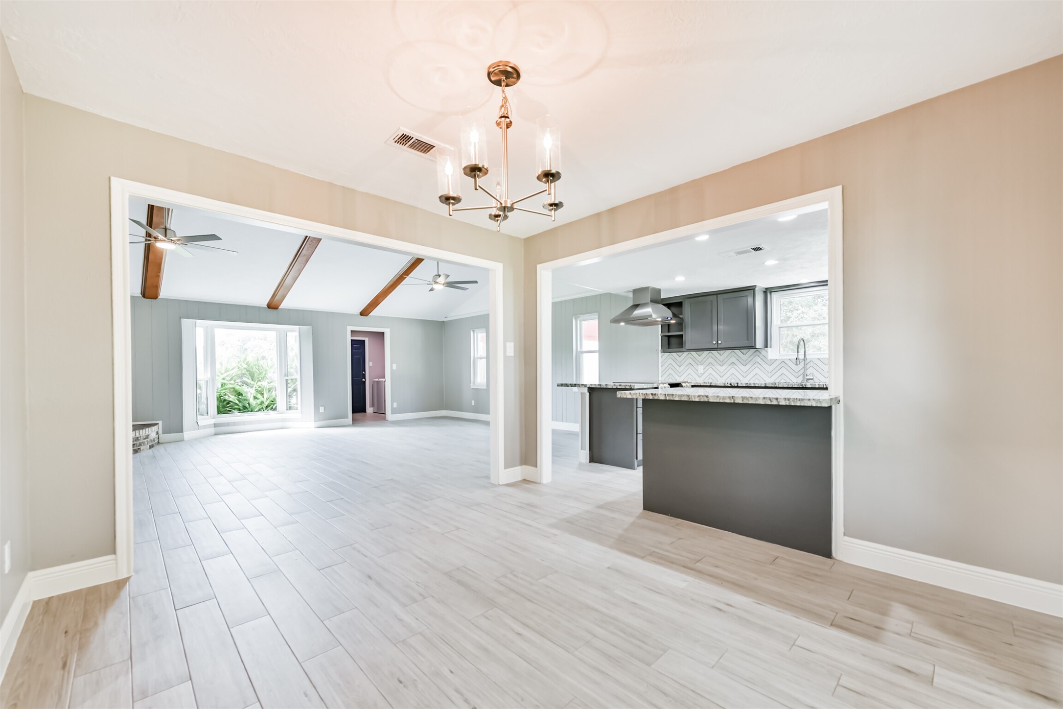 Enjoy your morning coffee in this inviting breakfast nook, featuring modern lighting and easy access to the kitchen and living area.