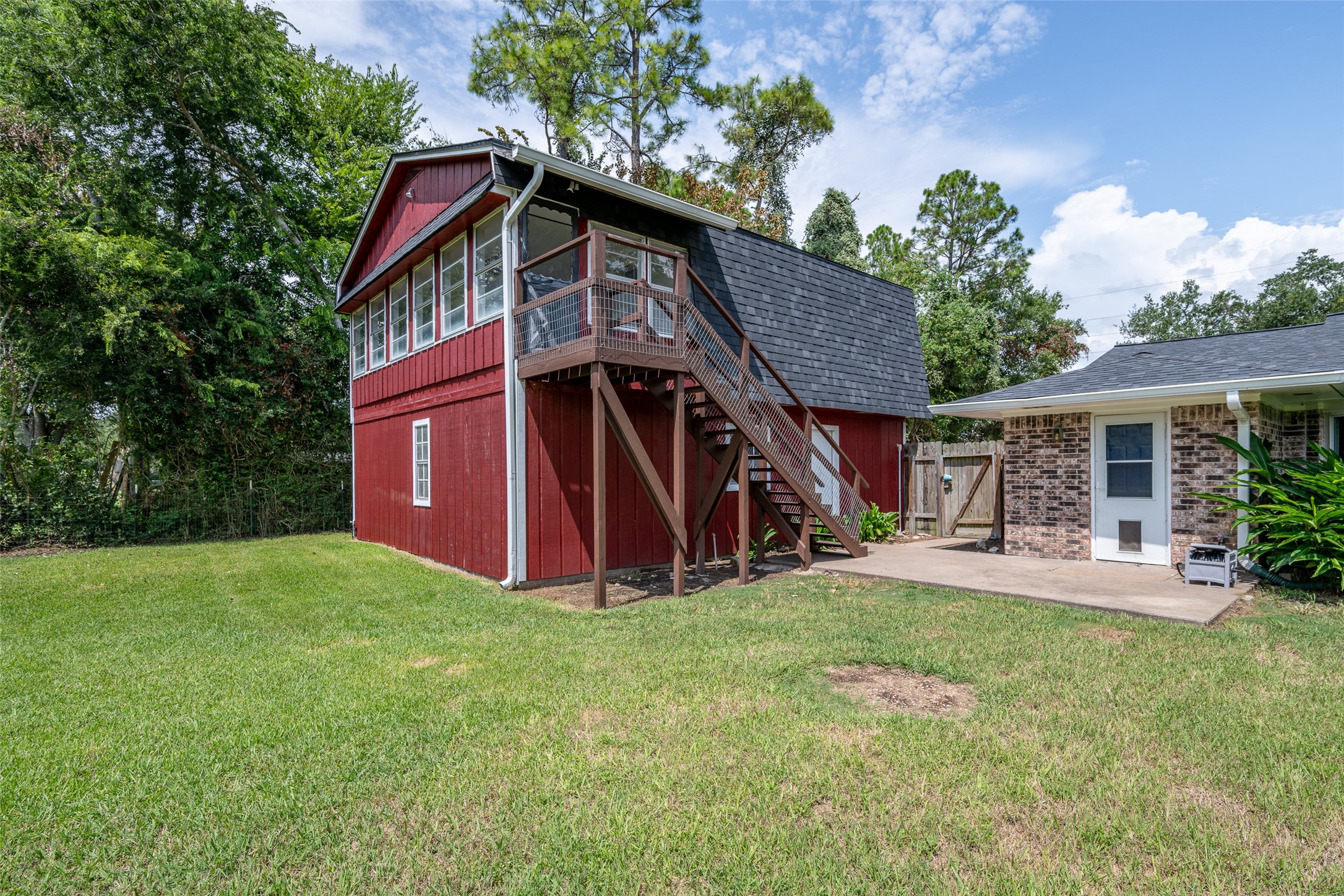 A view of the back of the home and bonus living quarters with a game room and sunroom