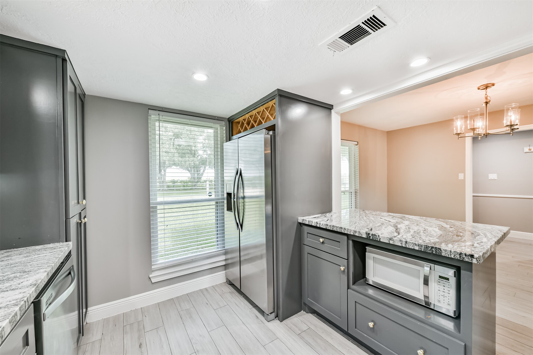 Modern kitchen featuring sleek cabinetry, stainless steel appliances, and elegant granite countertops, seamlessly flowing into the dining area.