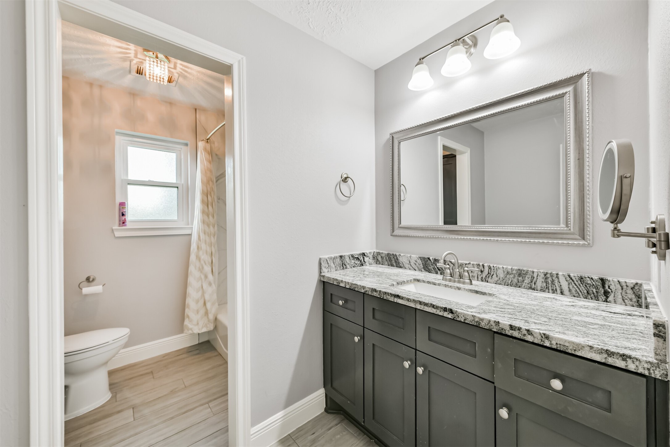 Luxurious full bath featuring a stylish dual-sink vanity, sleek granite countertops, and elegant fixtures, perfect for your relaxation and convenience.