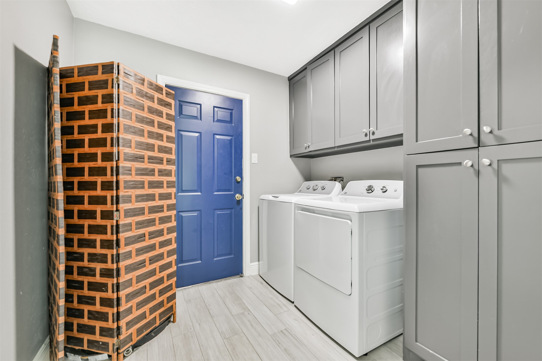 This well-organized utility room features ample cabinetry, modern appliances, and stylish finishes, offering both functionality and convenience.