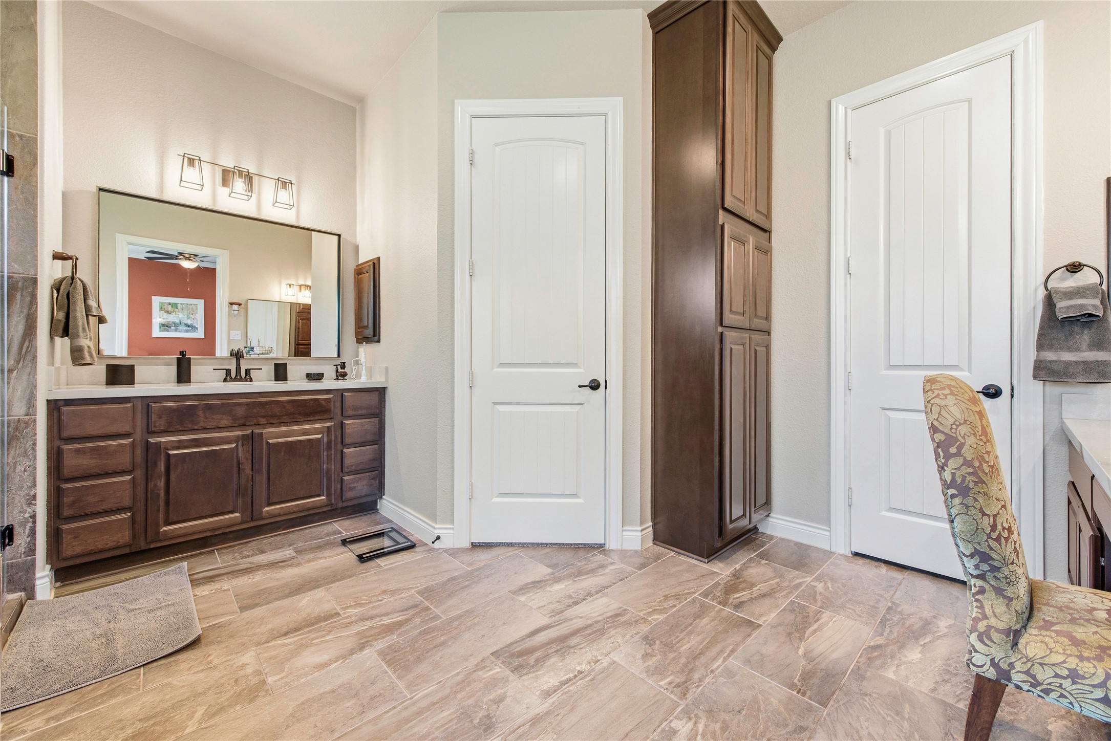 Well-appointed bathroom with double vanity, cabinetry and attractive finishes.