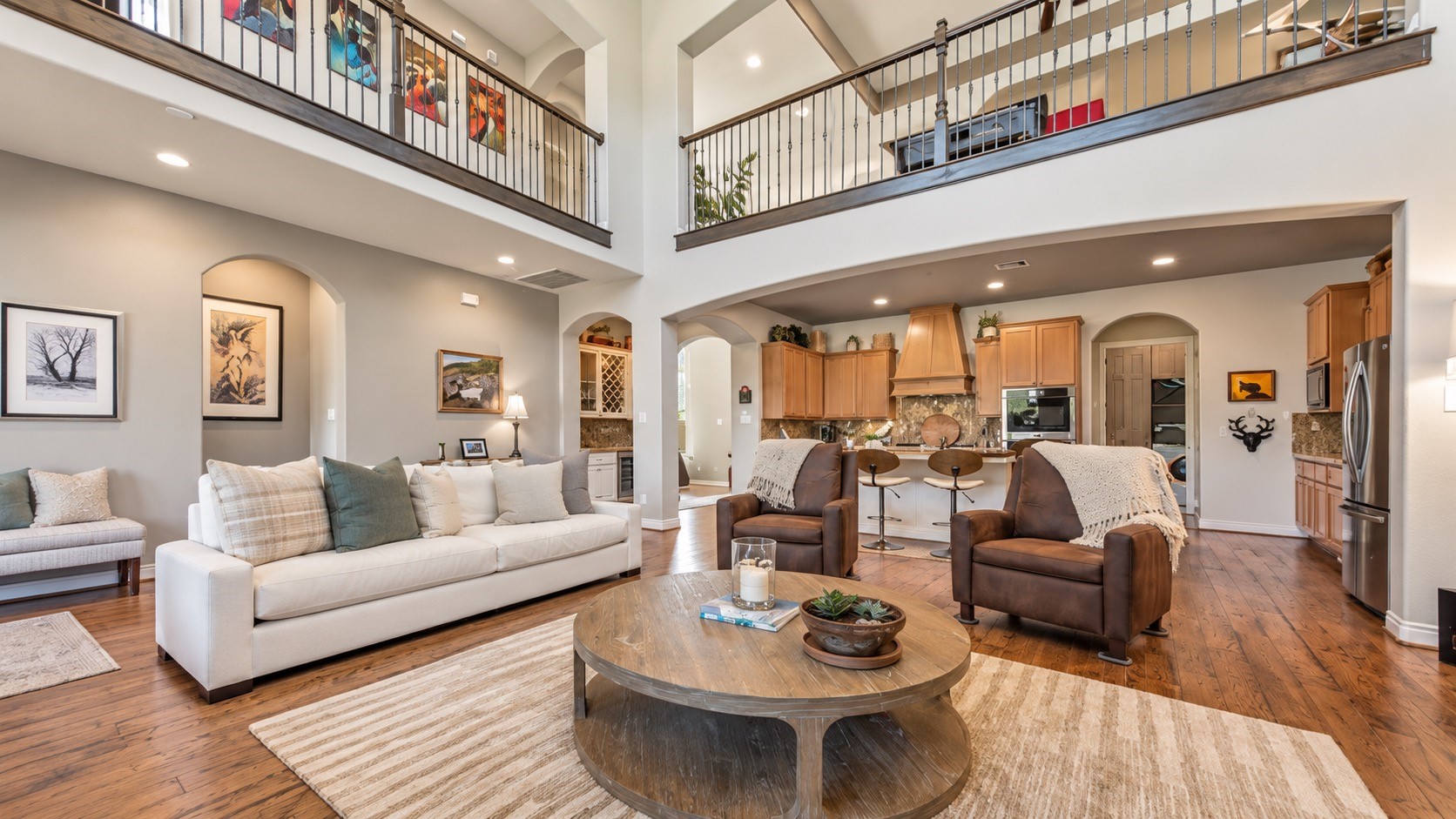 Open living space featuring high ceilings, fireplace, built-ins and views into the adjoining areas.